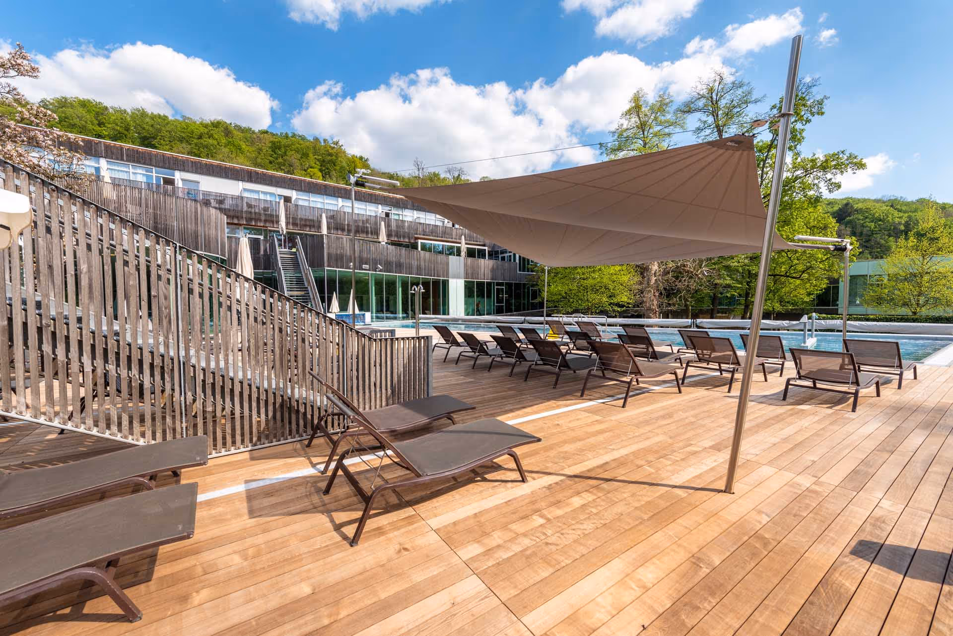 In das Holzdeck integrierte Bodenstützen - so stilvoll wurden die SunSquare Segel von Konrad Sonnensegel geplant und installiert.