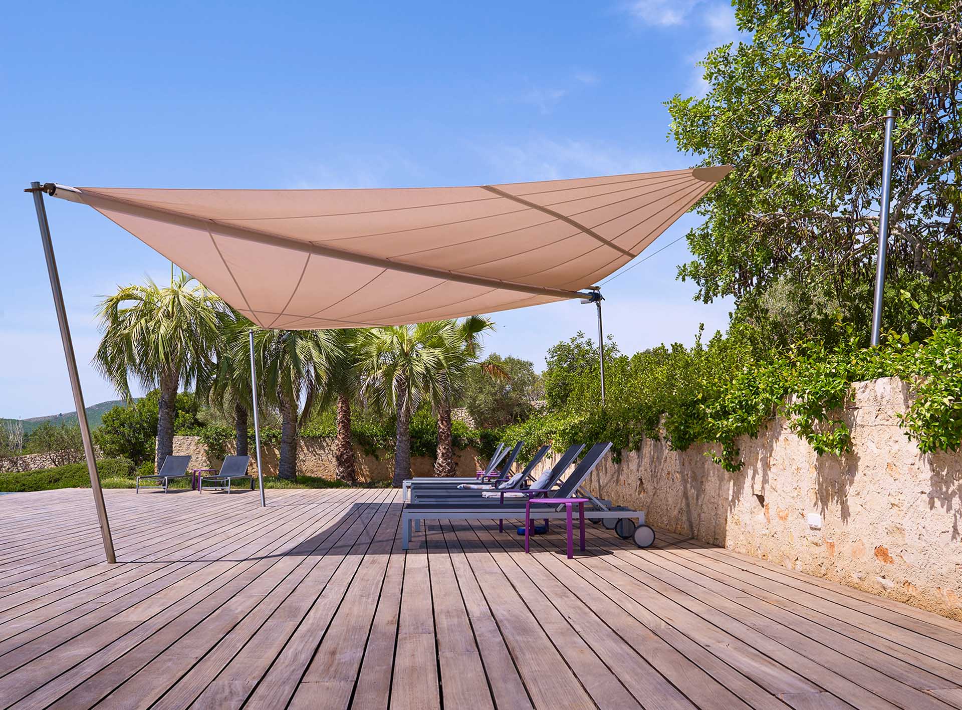 A free-standing SunSquare awning provides shade at an infinity pool surrounded by olive groves. Relaxing hours on the water. 