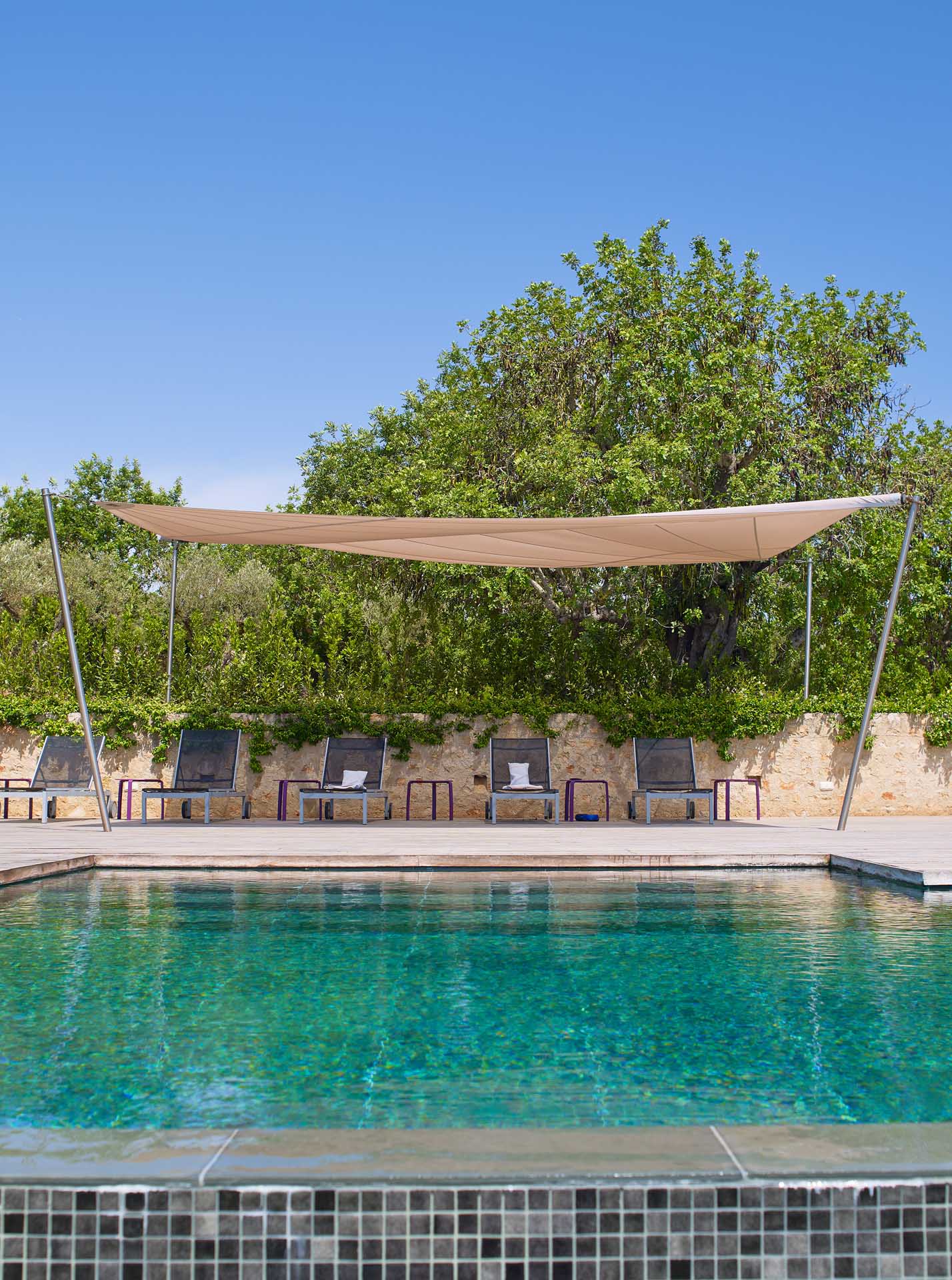 Infinity-Pool und SunSquare Sonnensegel für die Pool-Lounge.