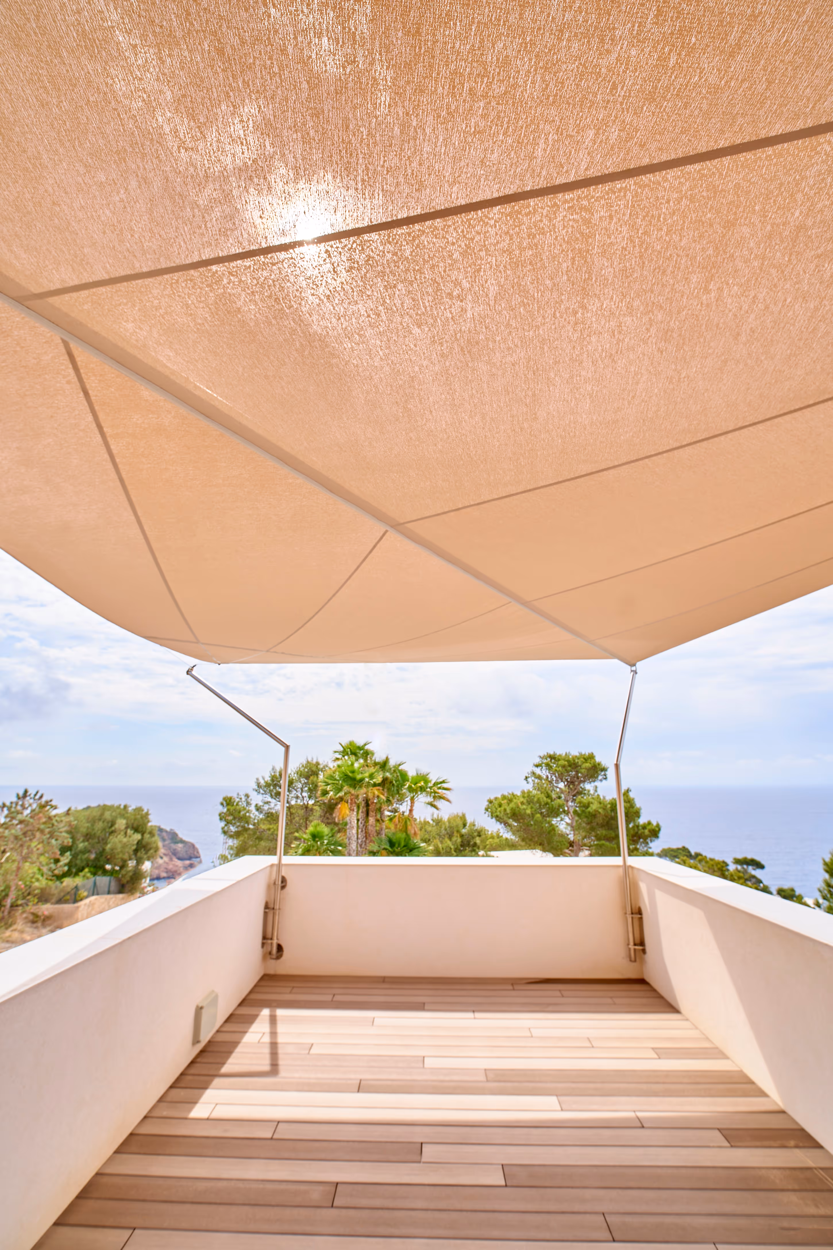 Drei SunSquare® Kompensator-Anlagen mit Knickstützen auf einer privaten Dachterrasse – stilvolle Beschattungslösung am Meer.