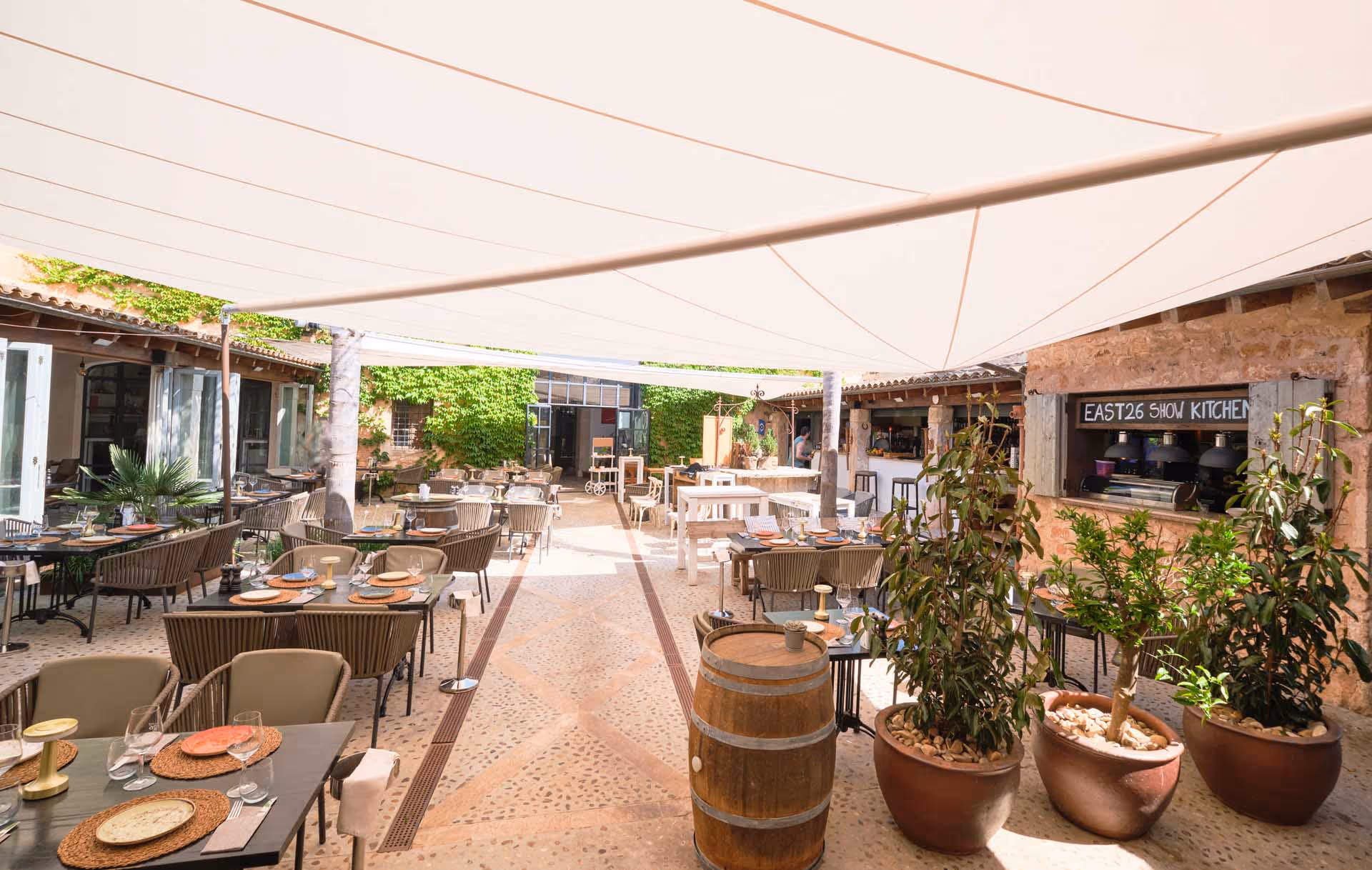 L'invitante cortile del ristorante alla moda East26 a Santanyí a Maiorca è protetto dal sole e dalla pioggia da tende resistenti alle intemperie in tessuto Infinity.