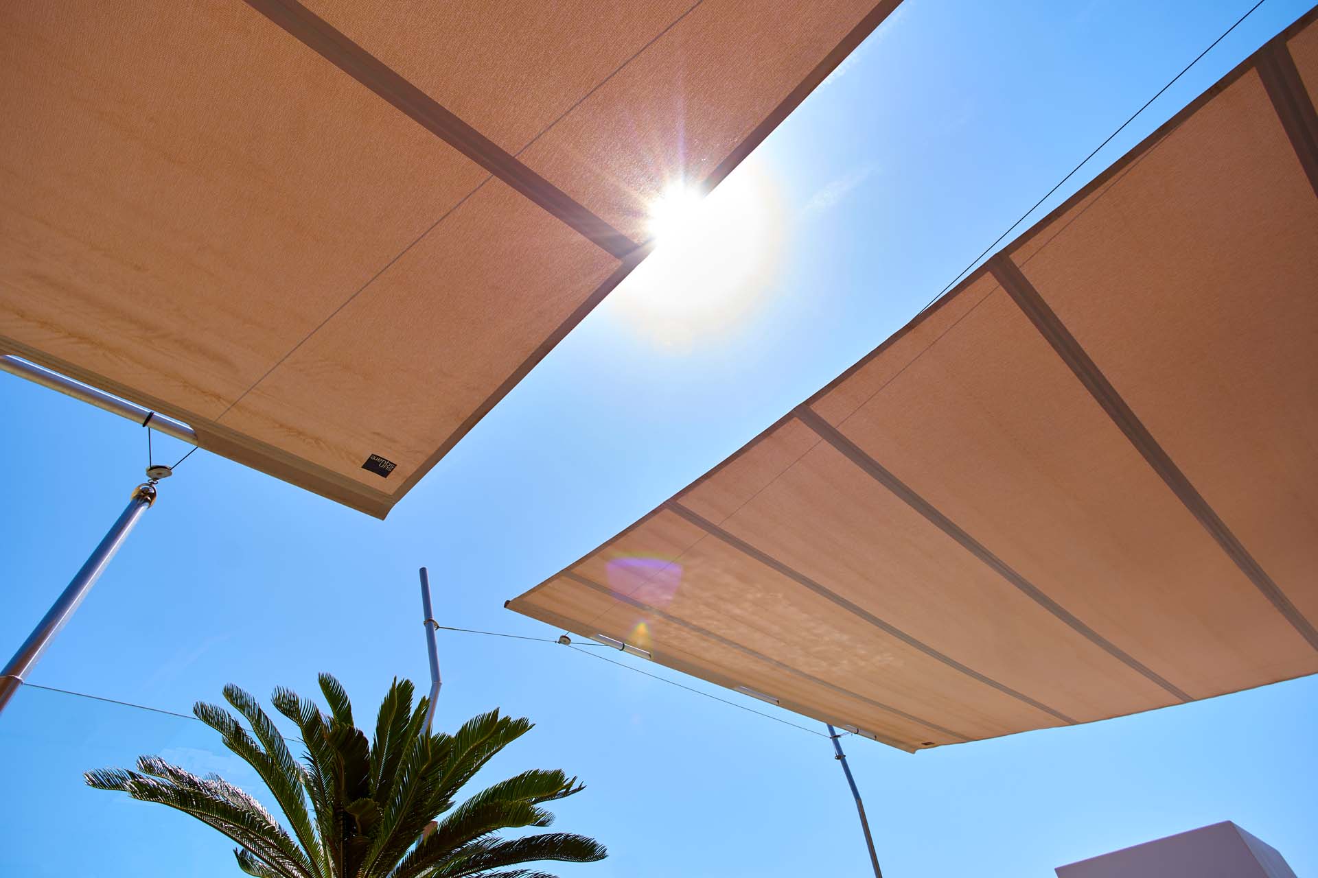 Automatisch gesteuerte Sonnensegel mit Windsensoren reagieren intelligent auf Wetterveränderungen.