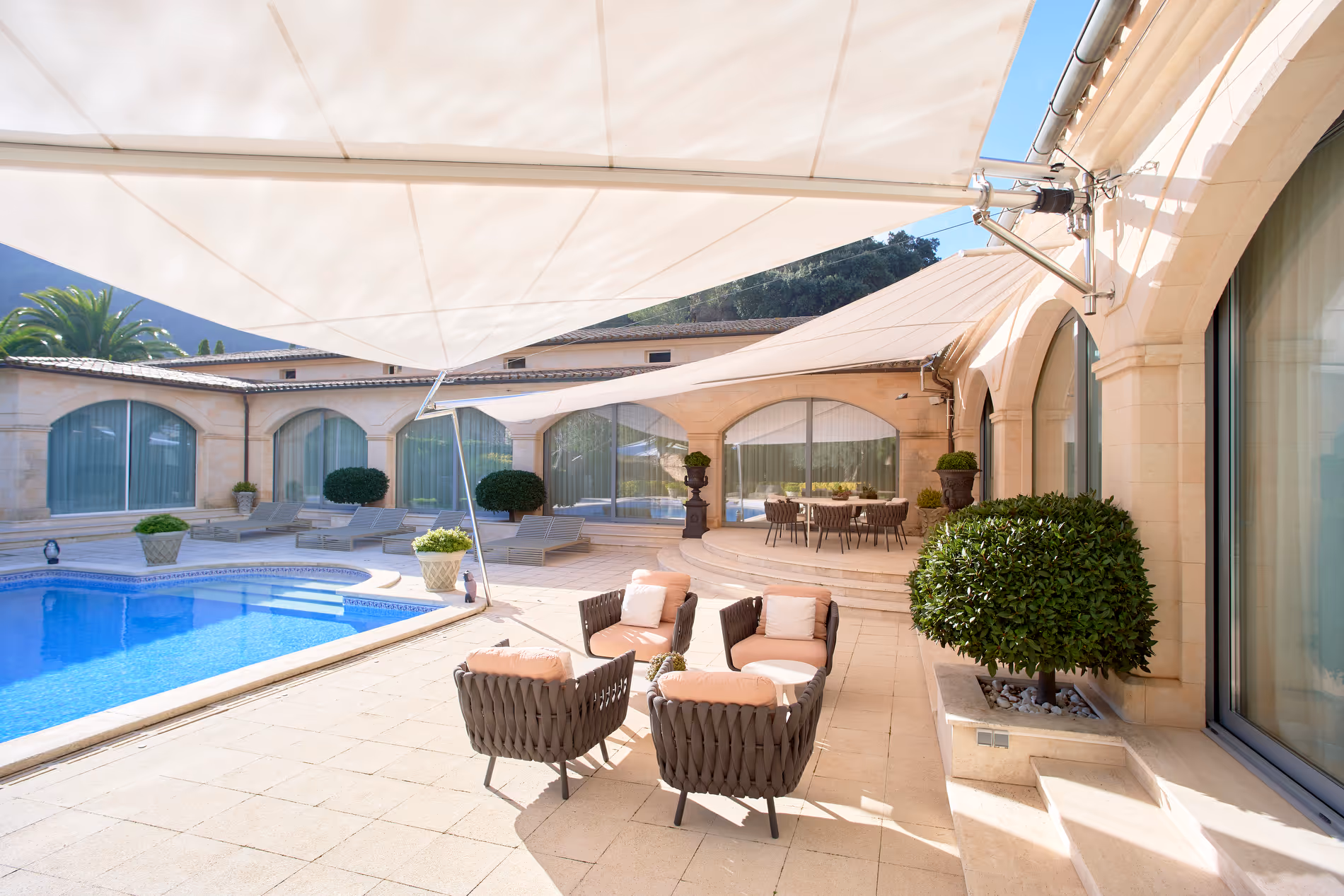 Three SQK-I sails with marine stainless steel articulated supports and certified welding technology around a hotel pool — stylish, durable sun protection.