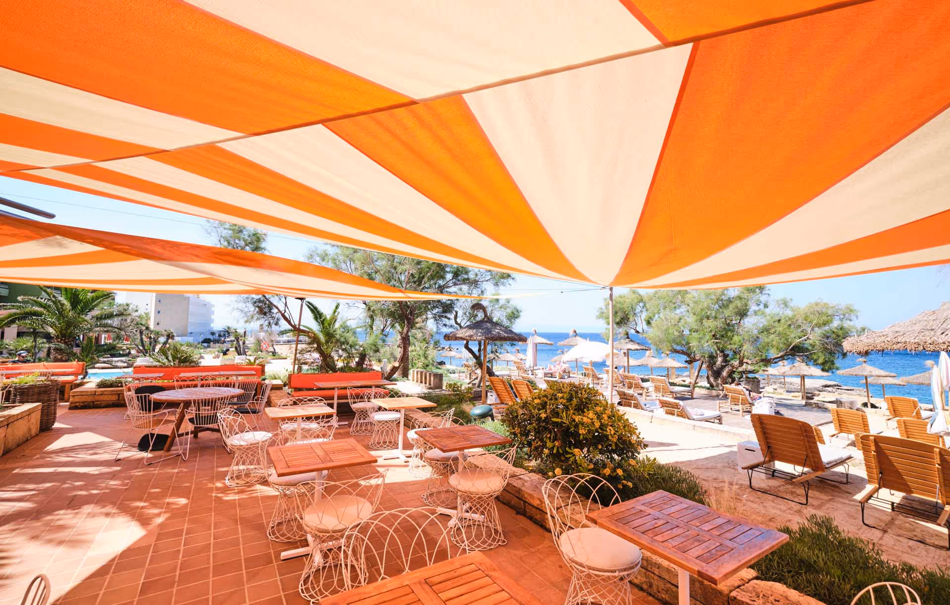 Tailored Boho Chic style awnings in the outdoor area of Bikini Hotel Mallorca, harmoniously integrated into the colorful, Mediterranean ambiance.