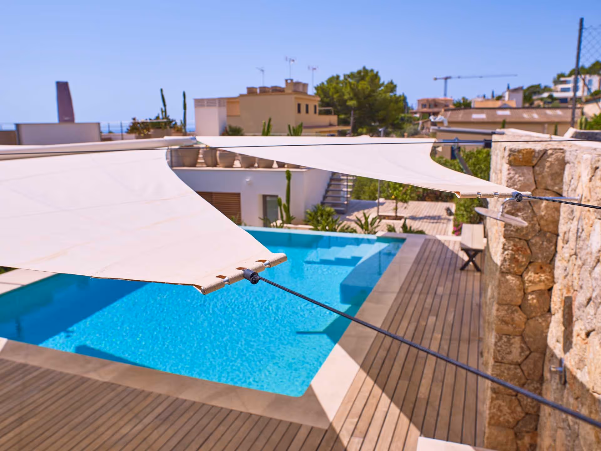 Sonnensegelanlage ohne F-Stützen ermöglicht uneingeschränkte Bewegungsfreiheit rund um den Pool.