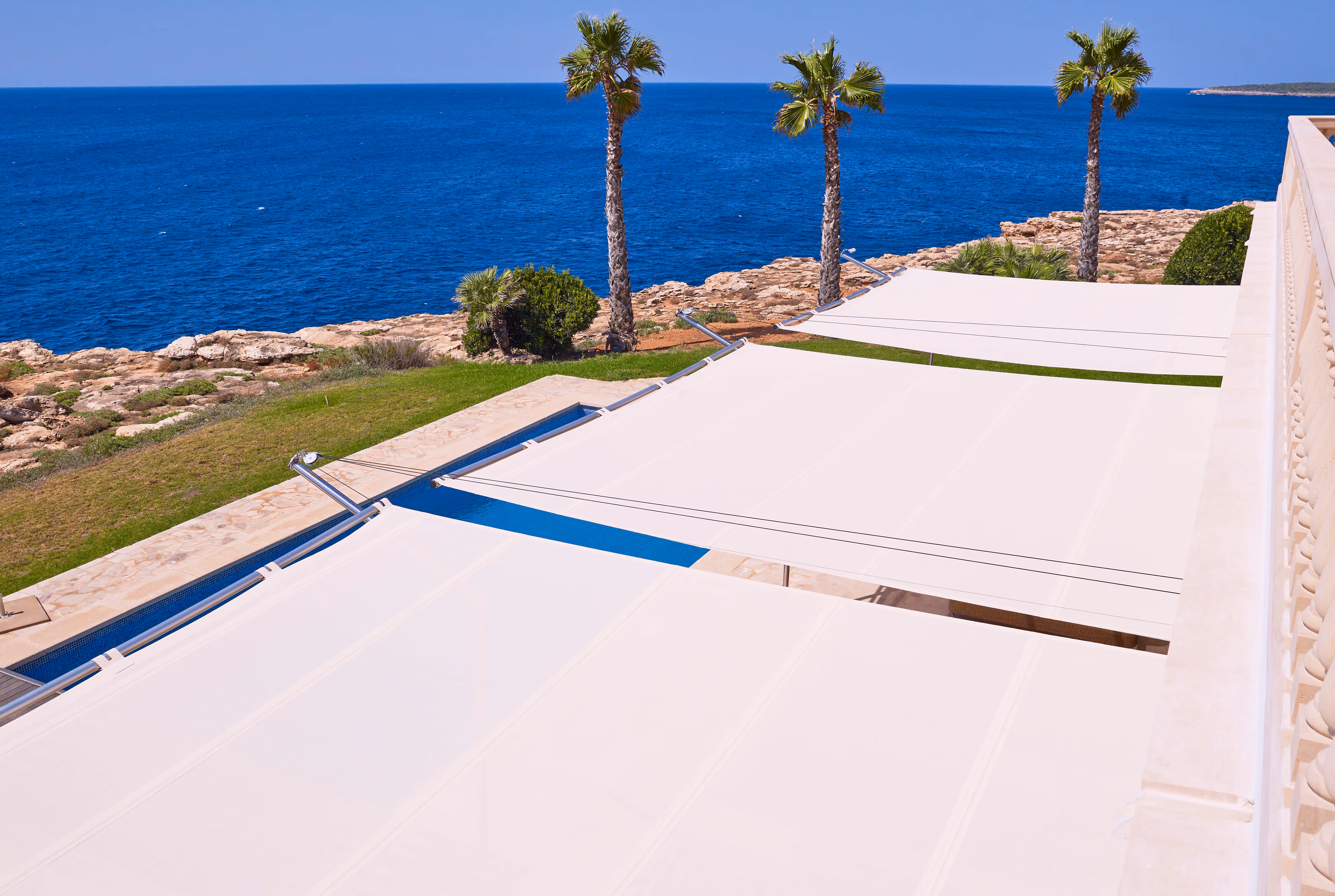 Three single-sided rectangular sails planned and built by Incompar Balear provide shade around the pool and provide unobstructed views of the nearby sea.