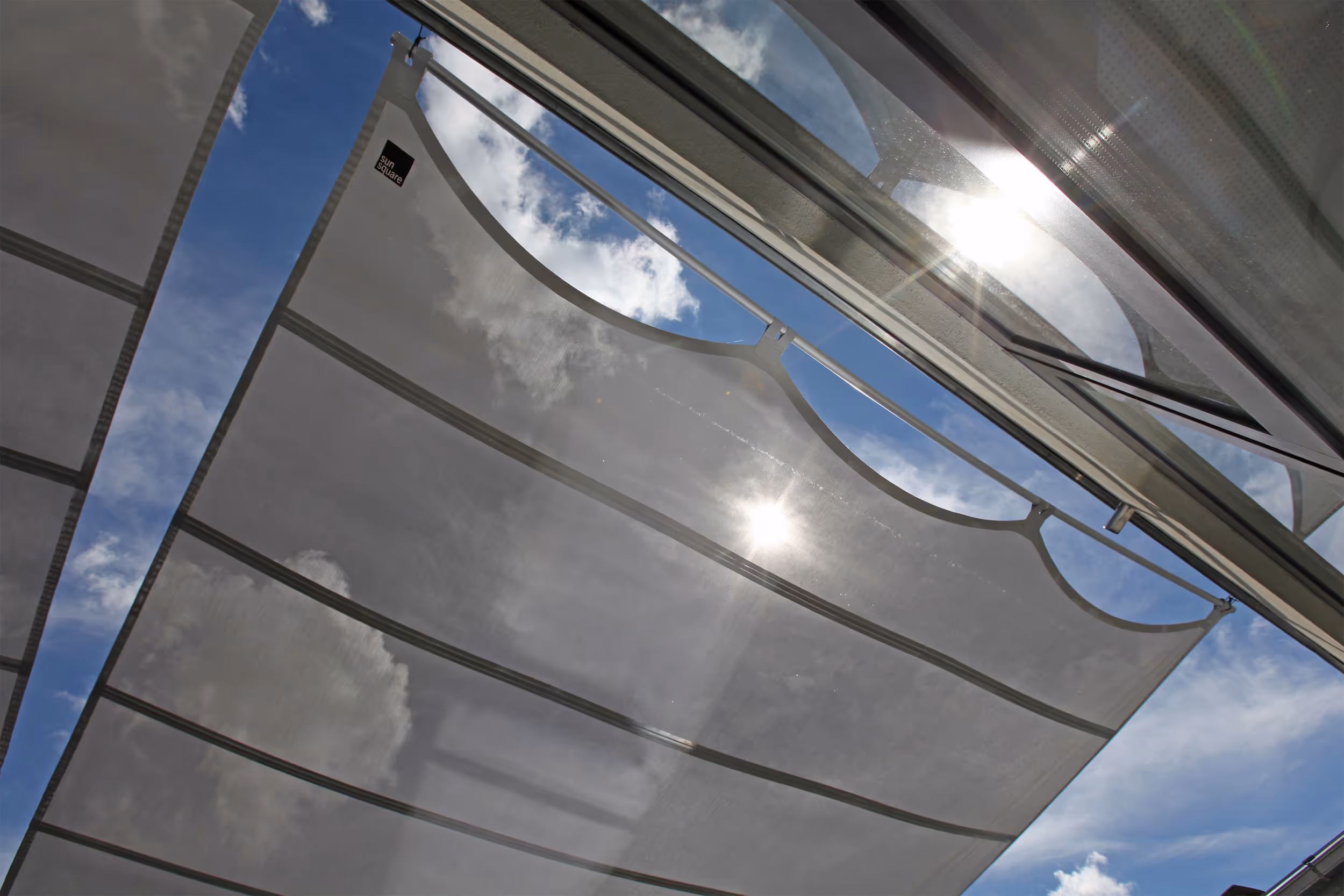 Doppel-AX-II Sonnensegelanlage mit 88 m² Fläche bietet eleganten Sonnen- und Blendschutz für die Lobby.