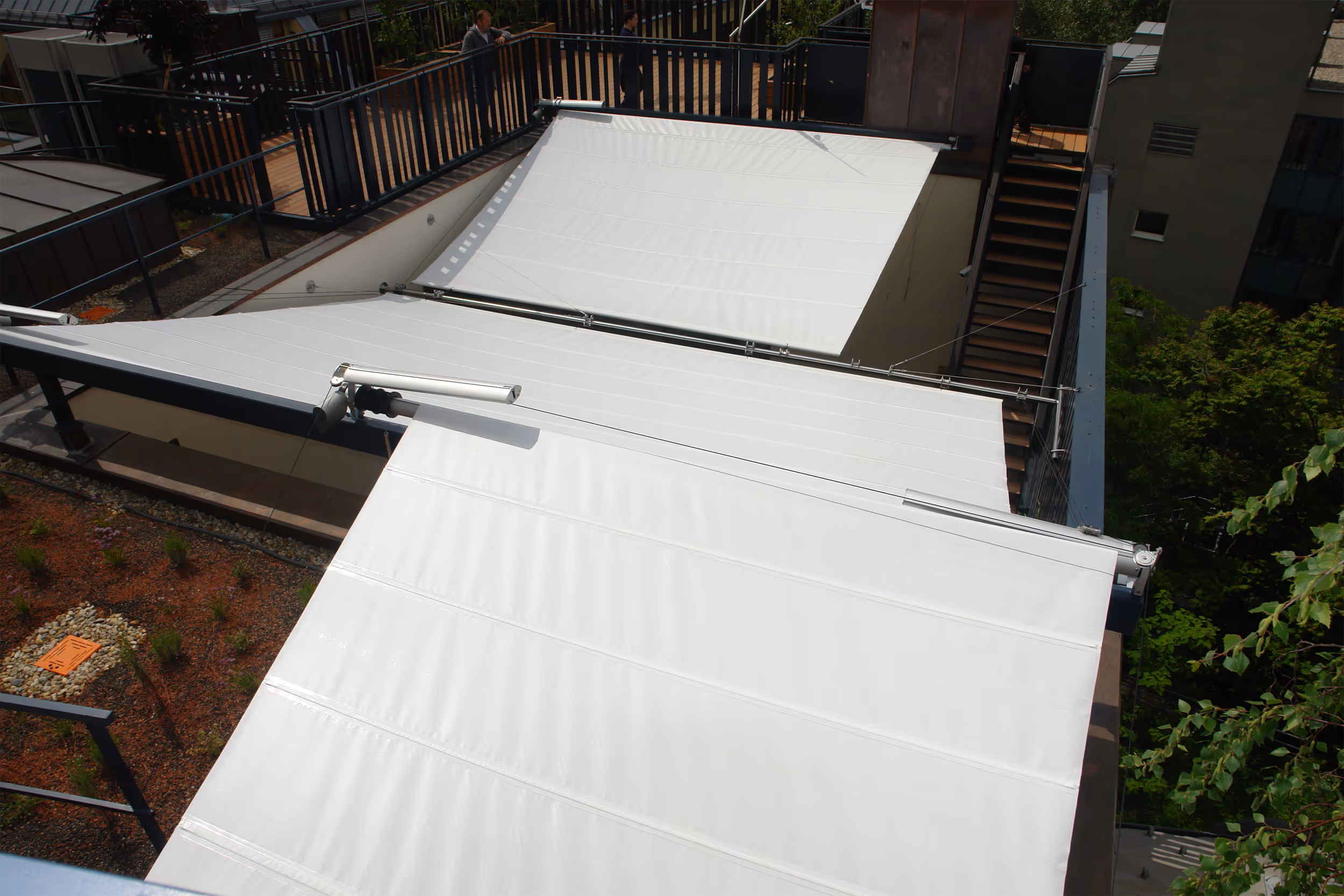 Three single-sided rectangular sails on different floors shade the underlying terraces. Urban design with SunSquare as an alternative to awnings.