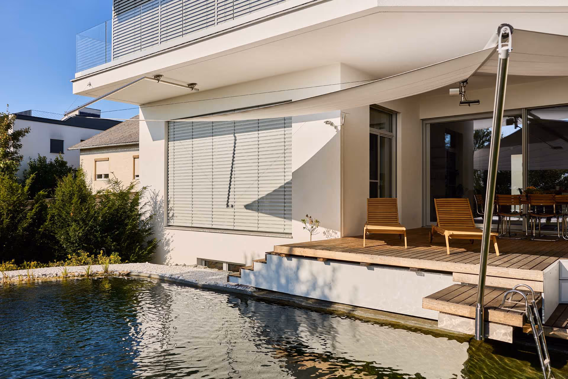 Wie zwei Elemente einer Komposition verbinden sich Schwimmteich und Holzdeck zu einem stimmigen Ensemble, das Ruhe, Ästhetik und Funktion miteinander vereint.