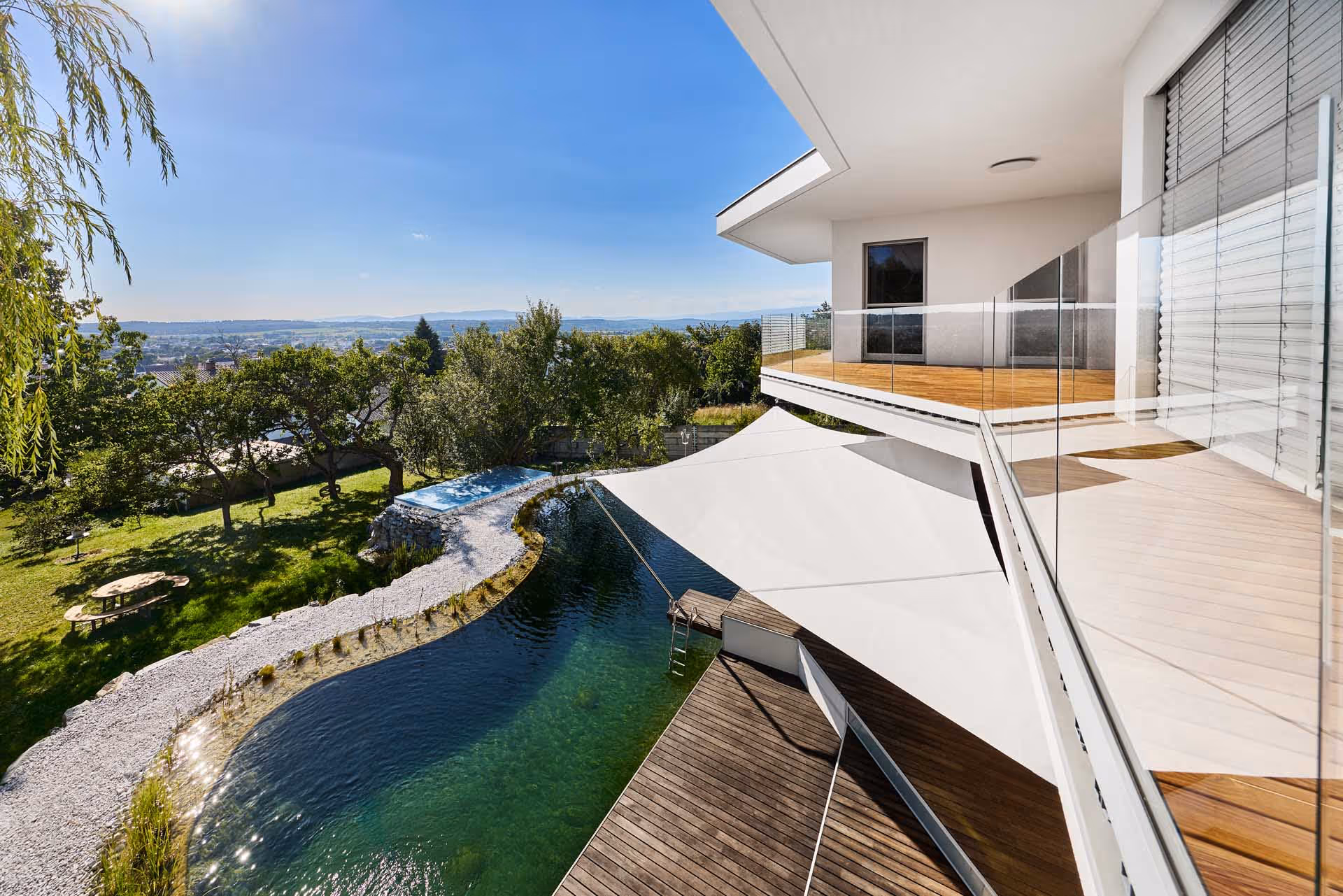 Maßgeschneiderte Lösung für zweistufiges Holzdeck mit angrenzendem Schwimmteich.