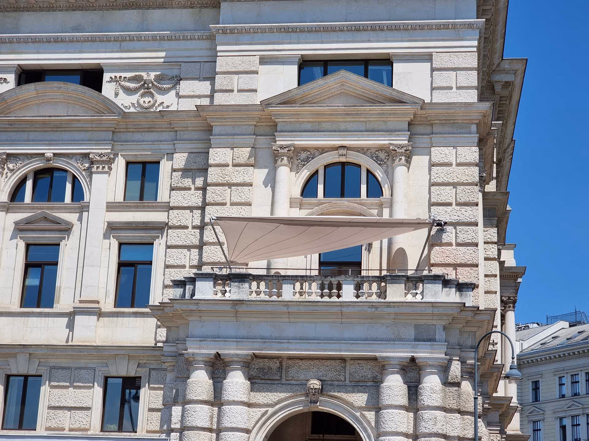 SunSquare Sonnensegel mit 35 m² Fläche bietet stilvollen Sonnen- und Regenschutz auf der Terrasse des Burgtheaters.