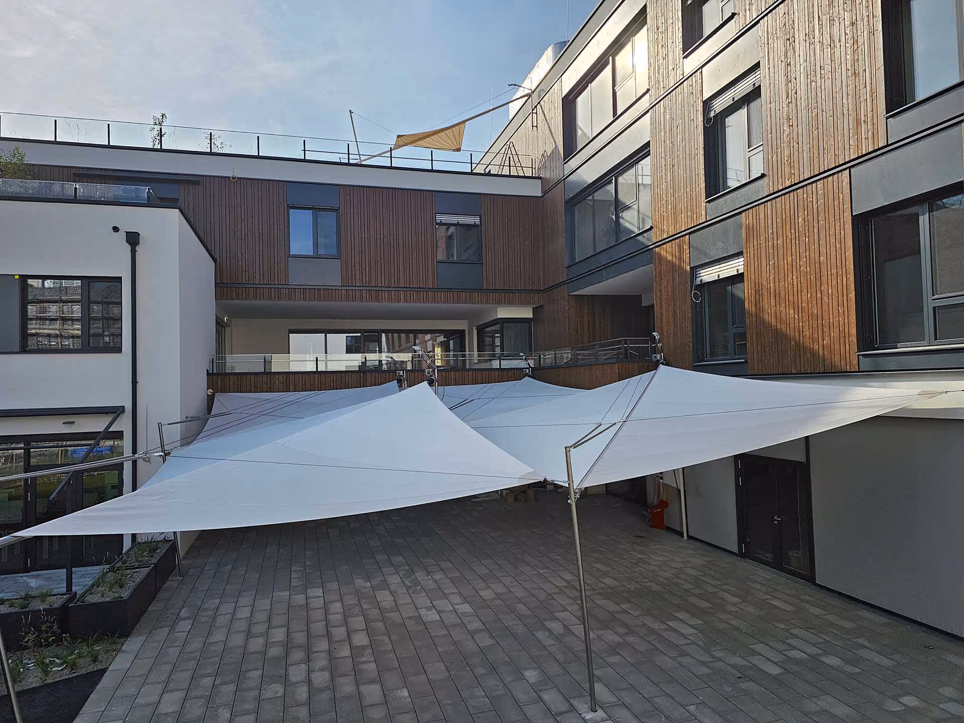 You can see a large outdoor area of a care facility. SunSquare awnings were built to protect this area from sun and rain.