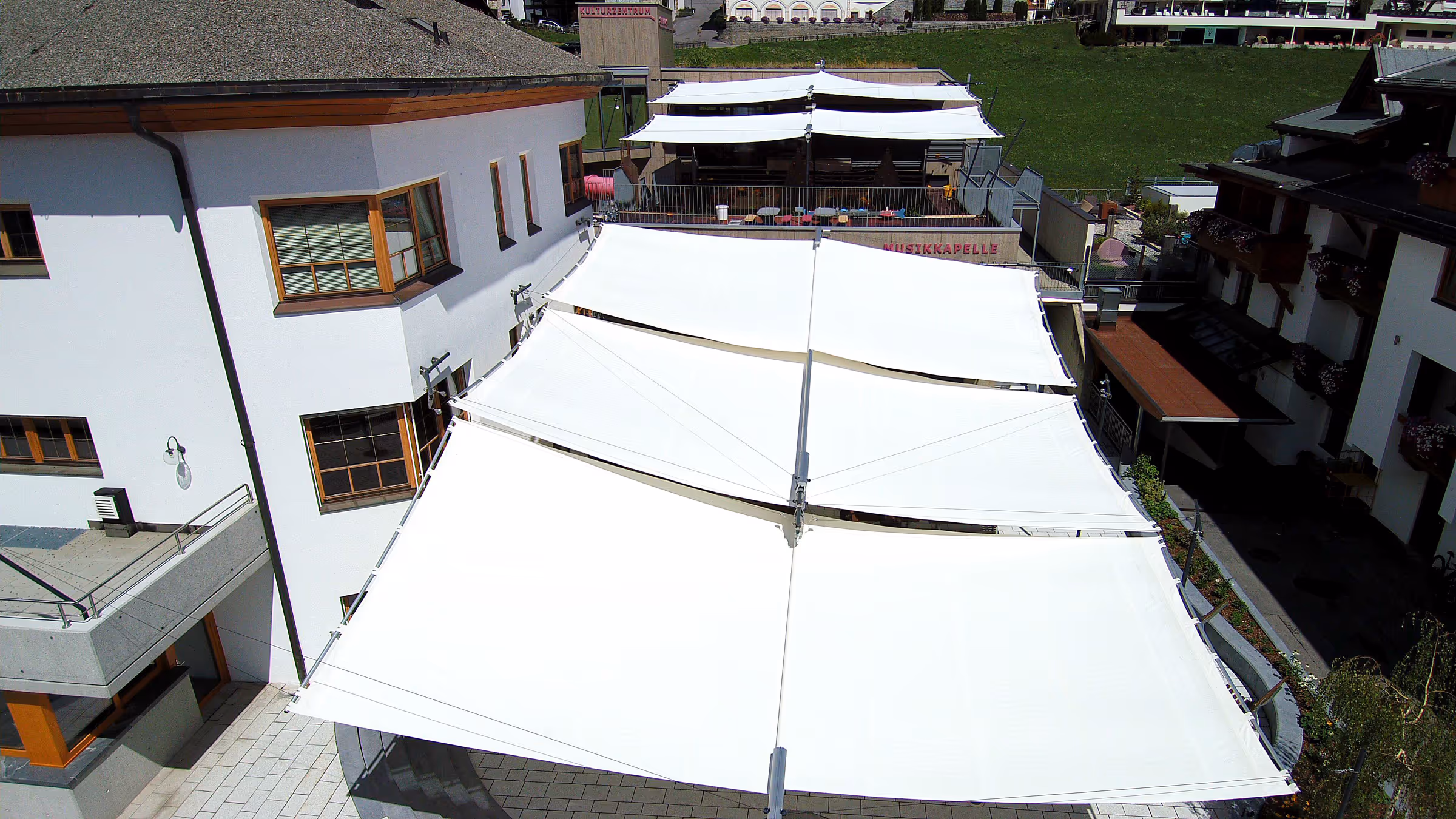 Klar strukturierte Segelanordnung fügt sich harmonisch in die Architektur des Vorplatzes ein.