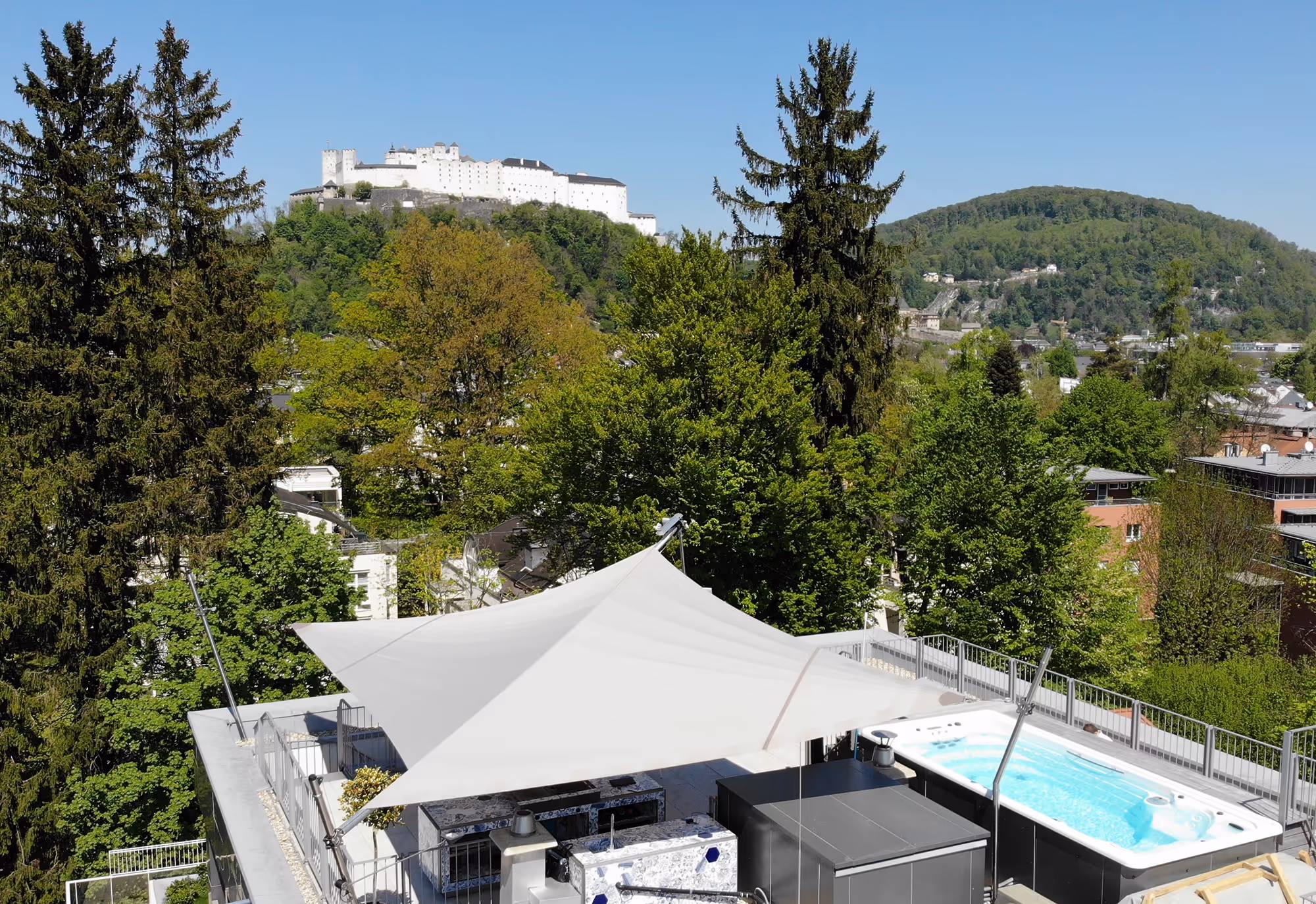 A spacious roof terrace in the heart of Salzburg with a swimming spa and awning, a SunSquare project with 3 height adjusters.