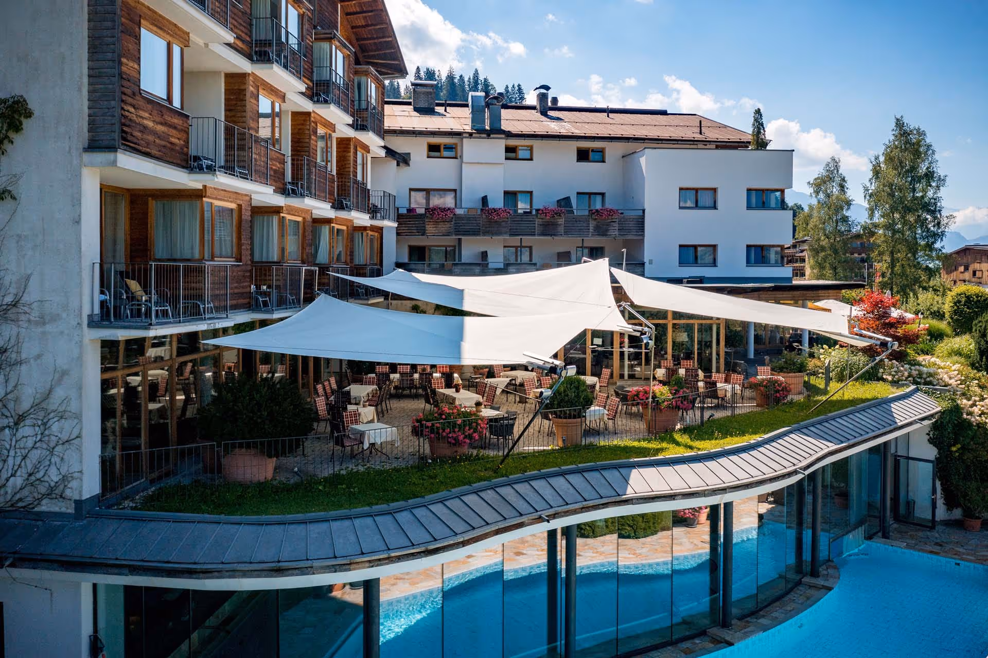 170 m² Segelfläche schaffen großzügige Schattenzonen auf der Terrasse inmitten alpiner Natur.