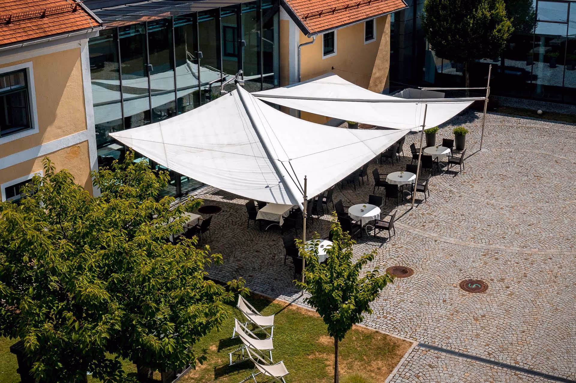Der Innenhof wird gerne für Firmenveranstaltungen genutzt und ist durch die SunSquare Segel länger nutzbar.