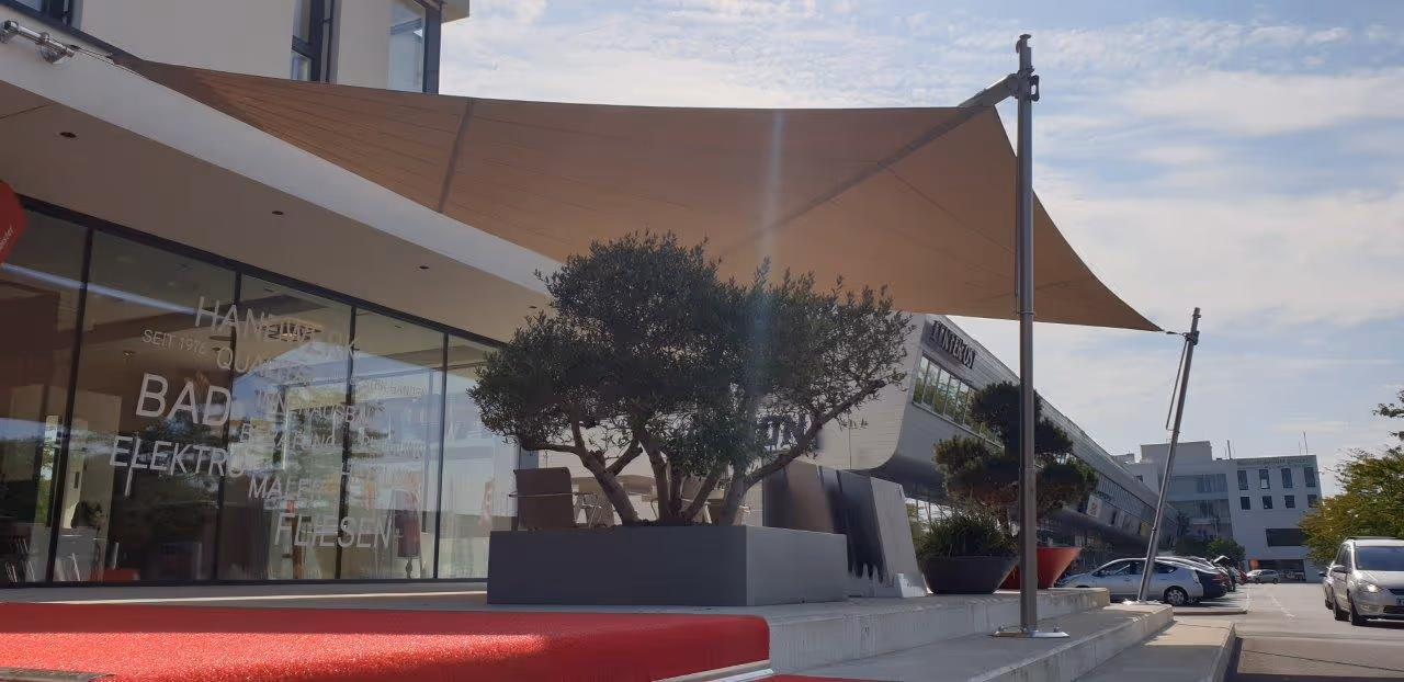 Die textile Beschattung bietet zuverlässigen Schutz für Kundengespräche und Events auf dem Vorplatz des Betriebsgebäudes.