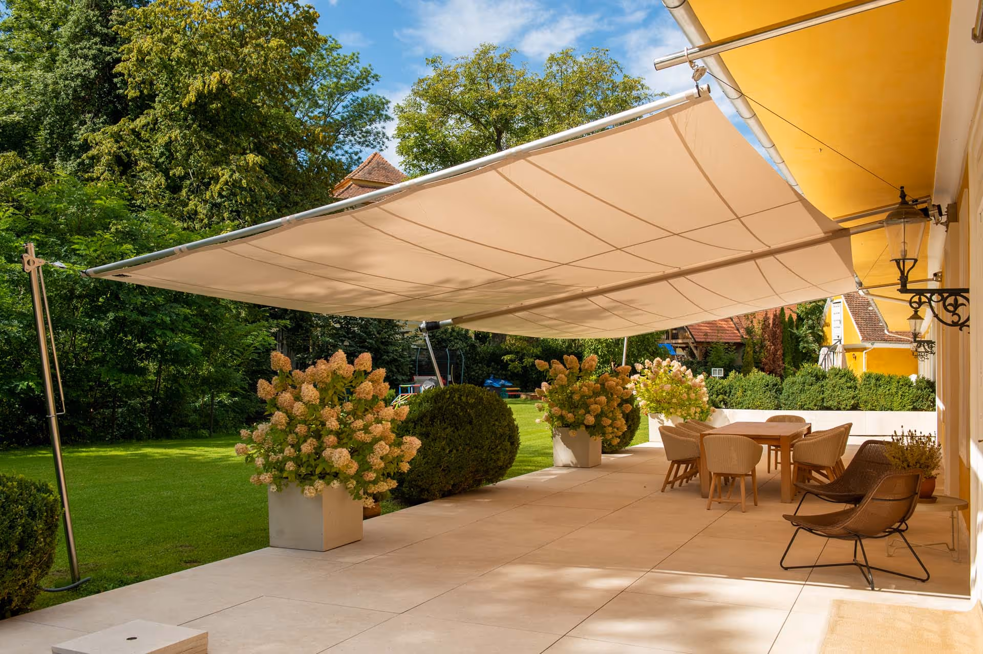 Großflächiges SunSquare-Segel über der Terrasse – stilvoller Sonnen- und Regenschutz mit über 65 m² Fläche.