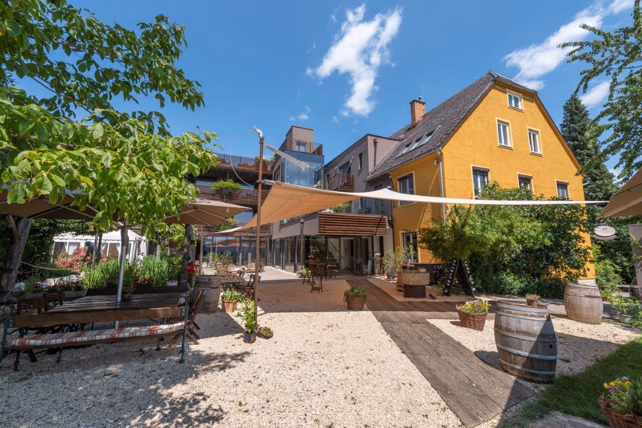 Großflächiges SunSquare-Strahlensegel über der Hotelterrasse – stilvoller Sonnen- und Regenschutz für gehobene Gastlichkeit im Freien.