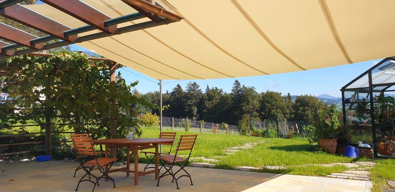 Einseitiges Rechtecksegel als eleganter Übergang zur Glasdachkonstruktion – dezente Integration in die bestehende Architektur.