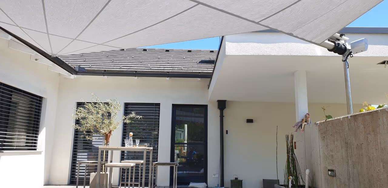 24 m² großes SunSquare-Segel aus Sattler Tuch 314-028 – stilvoller Sonnen- und Regenschutz mit dezenter Konstruktion.