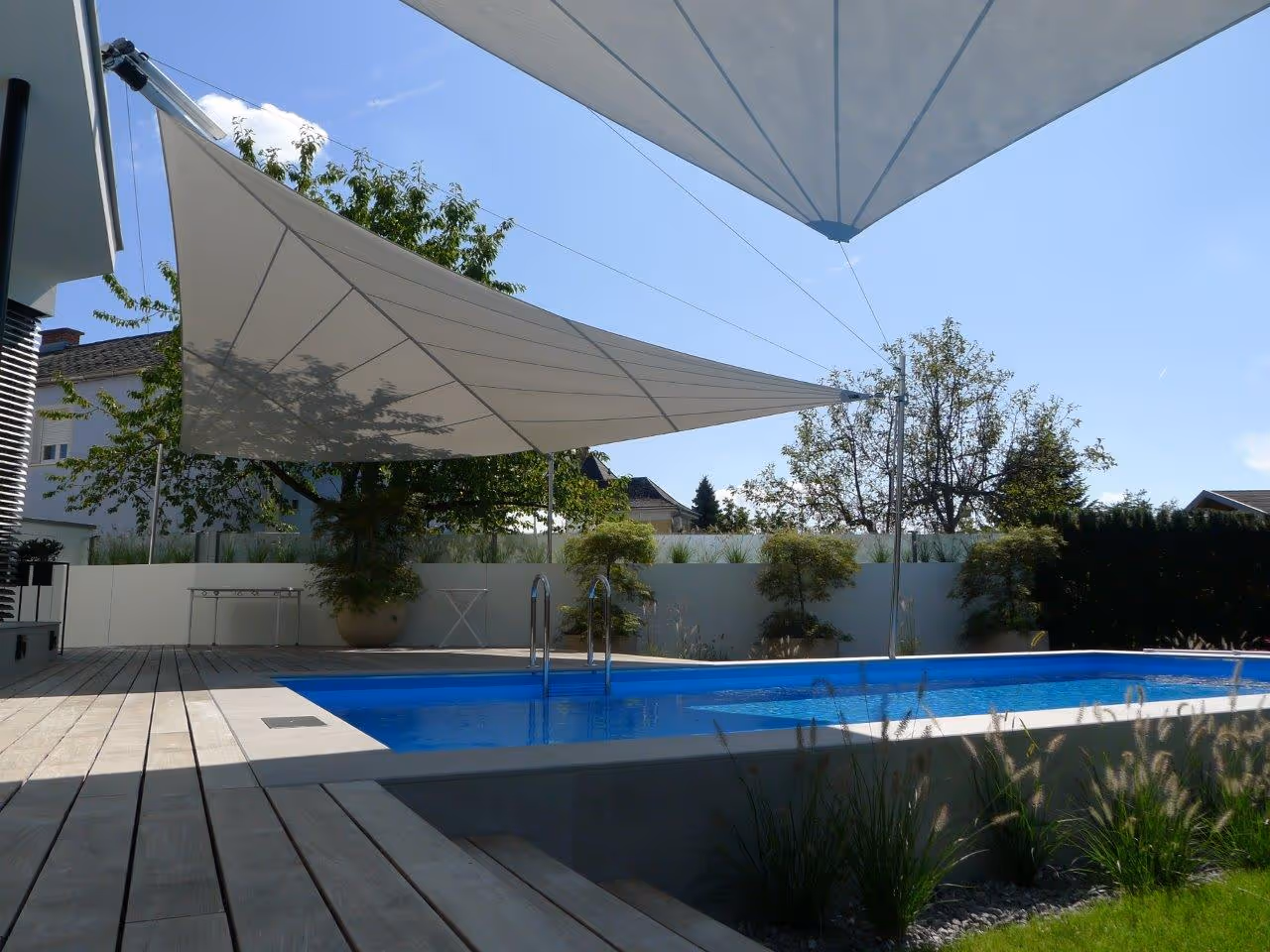 Strahlensegel mit manuellem Höhenversteller am Segelende – gezielte Abschirmung der Nachmittagssonne für verbesserten sommerlichen Wärmeschutz und Energieeffizienz.