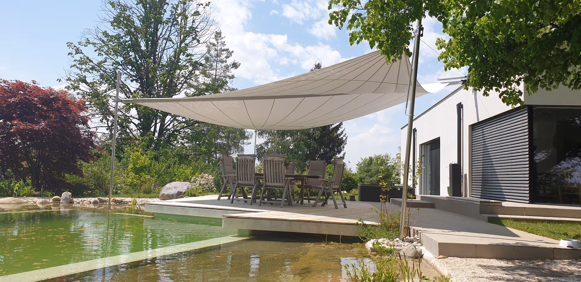 Das Sonnensegel mit zwei Höhenverstellern an den Segelenden schützt die Bade- und Sitzplattform perfekt vor Sonne und Regen.