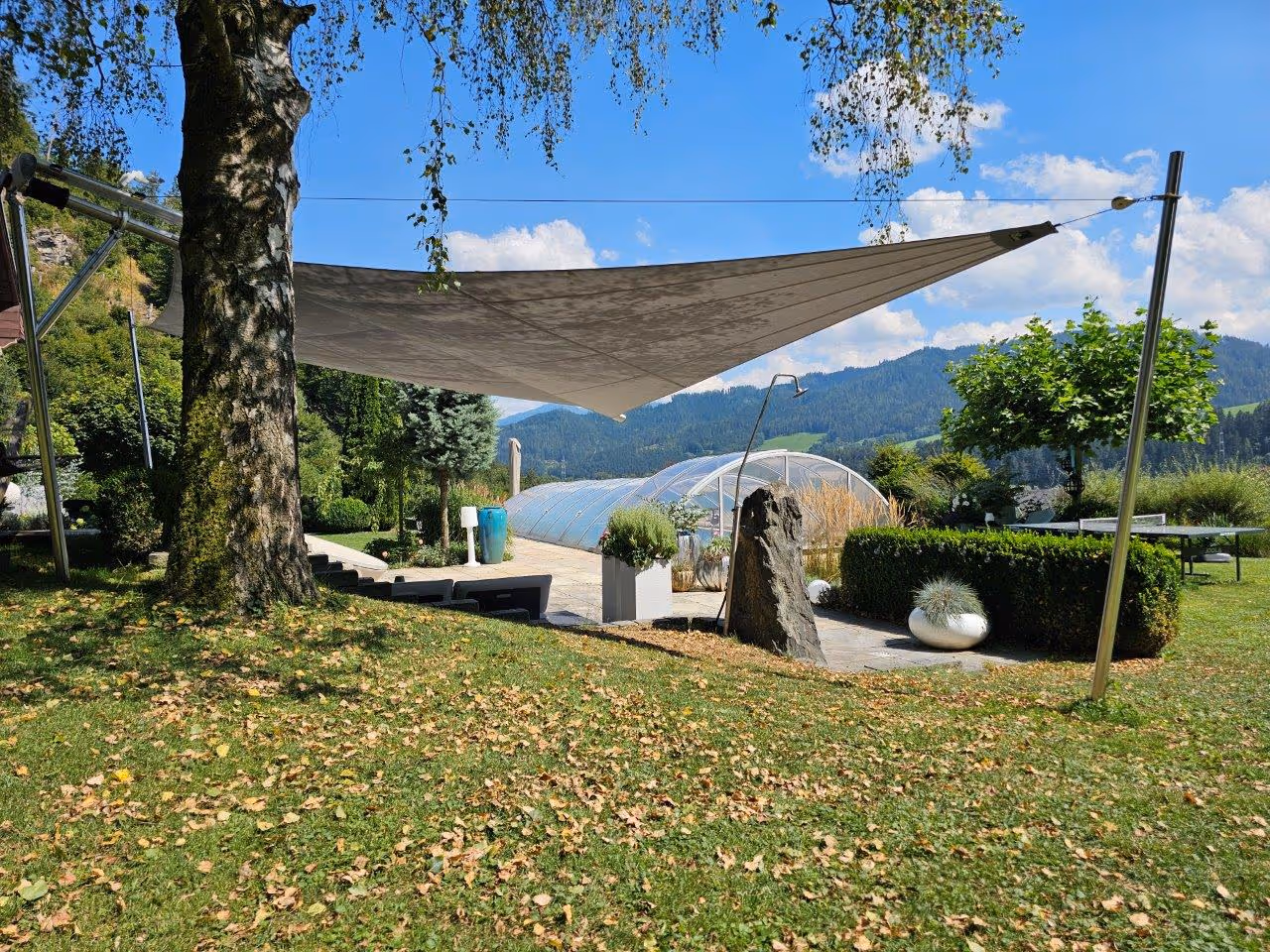 Blick von der Rückseite der SunSquare Cantilever Anlage auf den großzügigen Garten und den Sitzbereich.