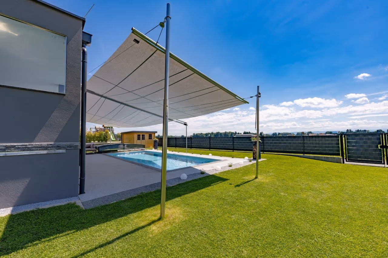 Eine beidseitige SunSquare Rechteck-Anlage schützt den Pool und den Außenbereich vor Sonne und Regen.