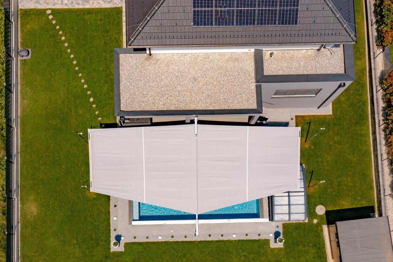 Eine Drohnenaufnahme zeigt, wie ein SunSquare Rechtecksegel von oben betrachtet aussieht. Hier erkennt man einen leicht trapezförmigen Zuschnitt.