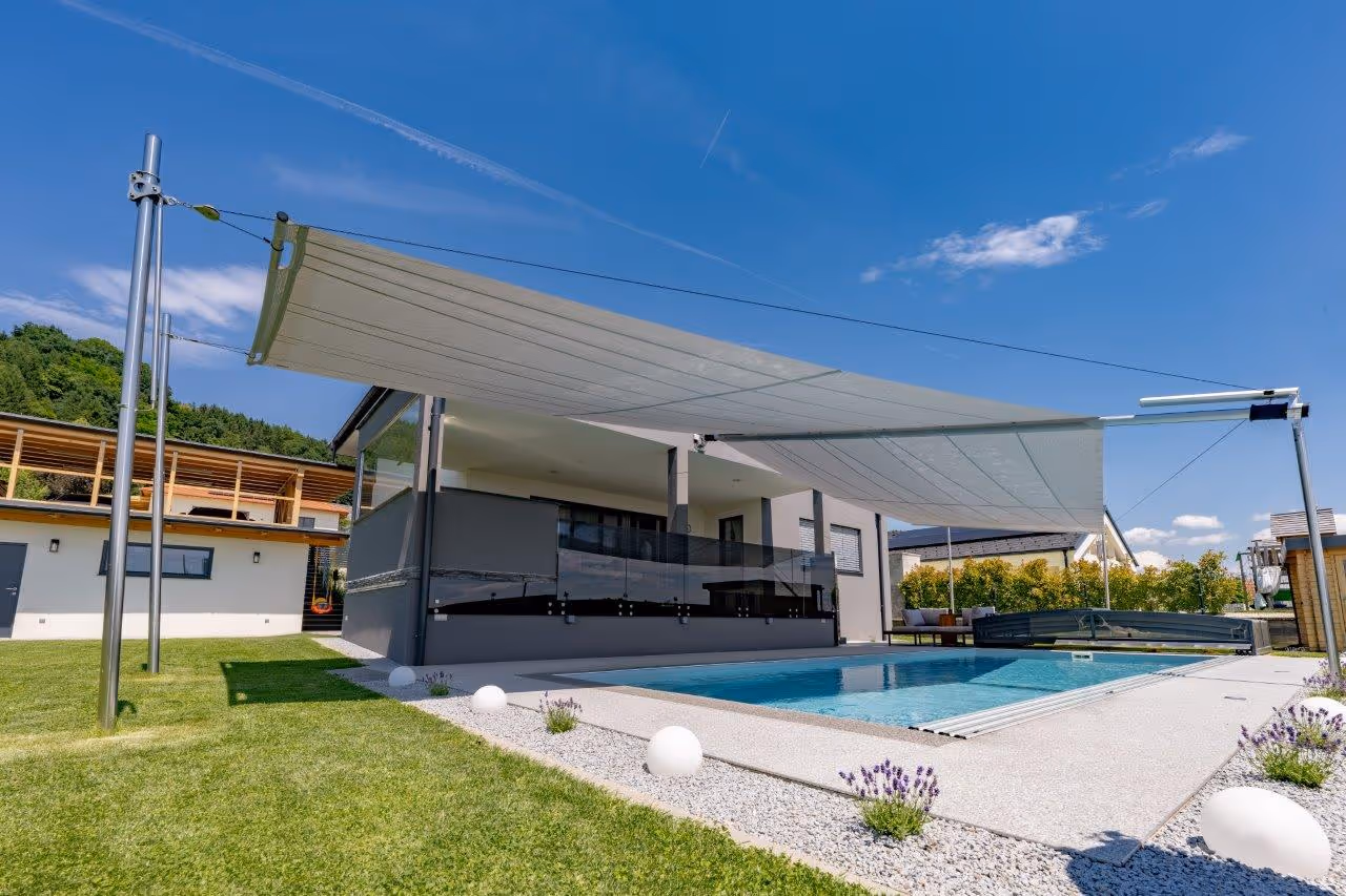 Stilvoll gestalteter Außenbereich mit beidseitiger SunSquare Rechteck-Anlage über dem Pool errichtet.