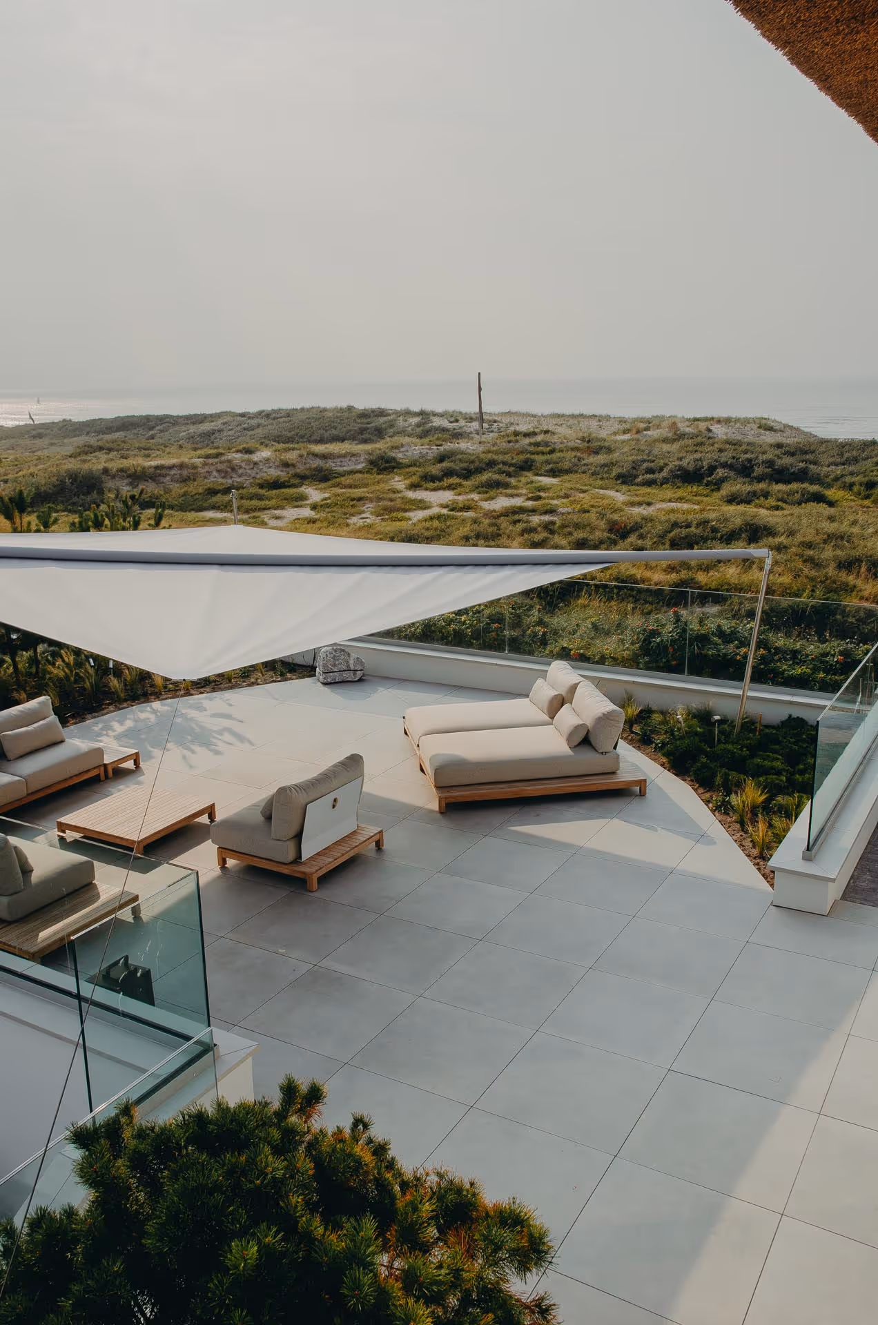 Die weitläufige Terrasse mit hochwertigen Outdoormöbeln ist nun perfekt vor Sonne und Regen geschützt. Danke SunSquare Sonnensegel.
