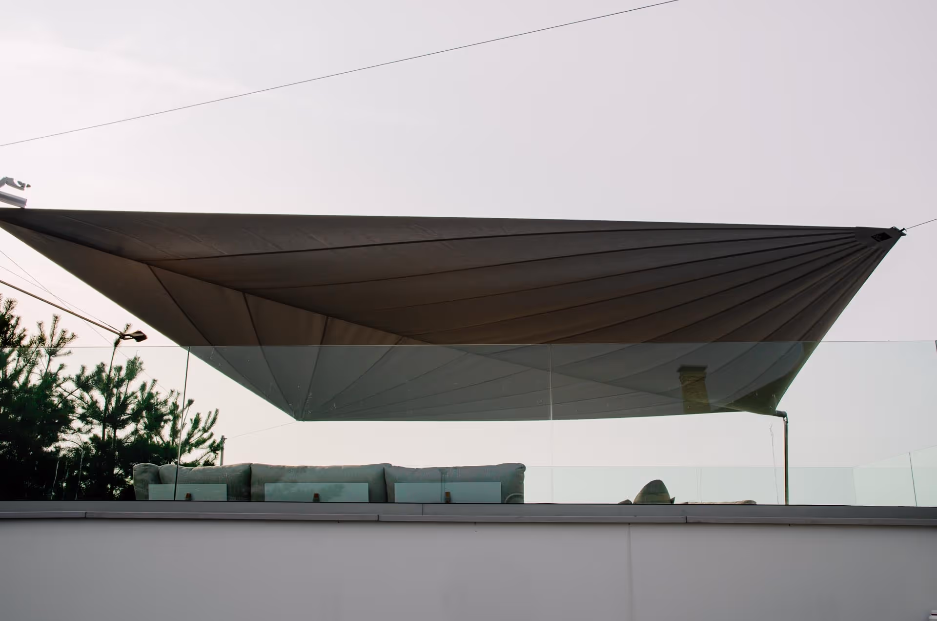 Ein Blick von unten auf das geöffnete Segel, eindrucksvoll wie es die Terrasse schützt.