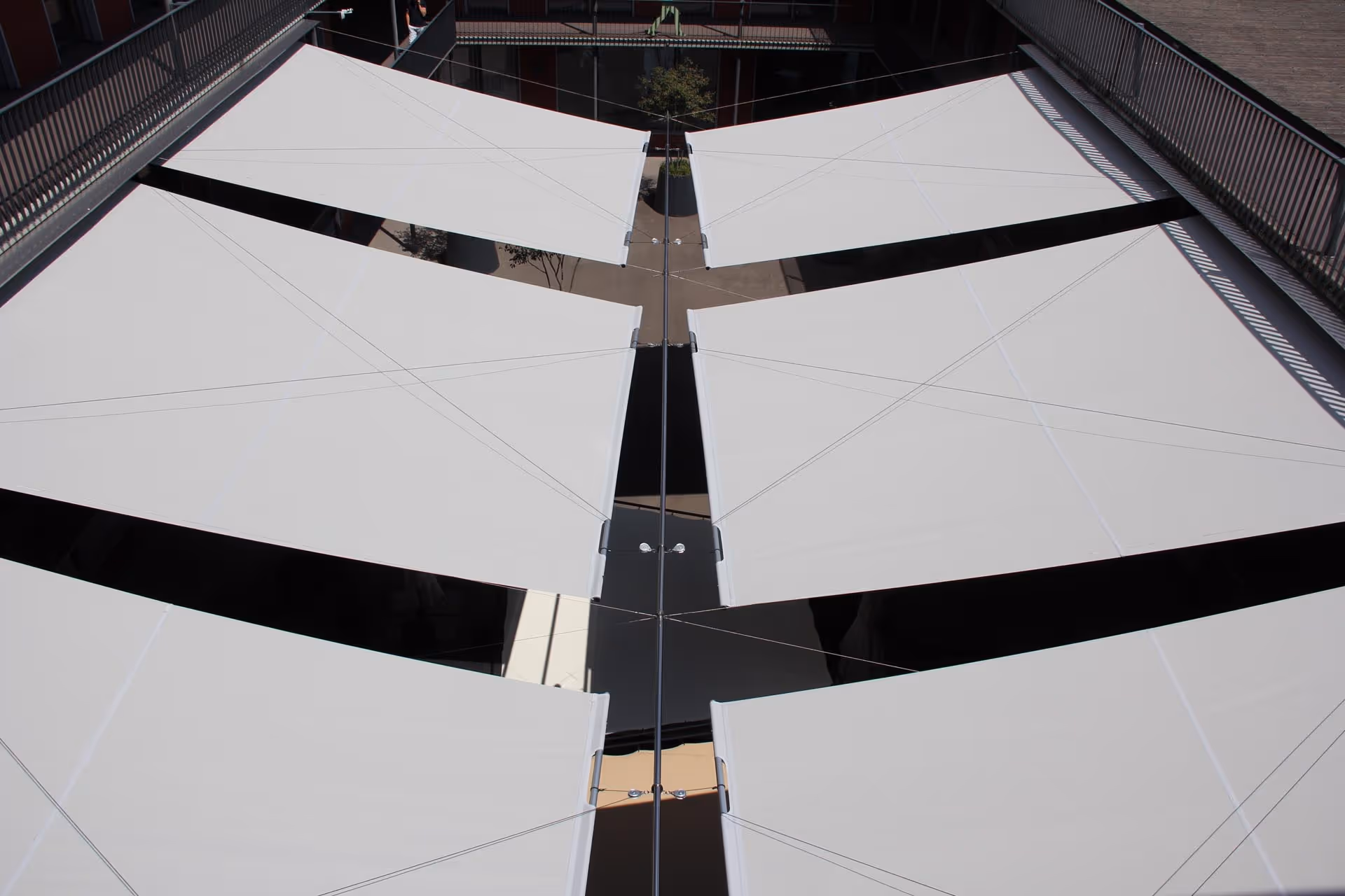 Über 200 m² textile Beschattung auf einer öffentlich zugänglichen Dachterrasse – klare Linien und harmonische Integration in die Architektur.