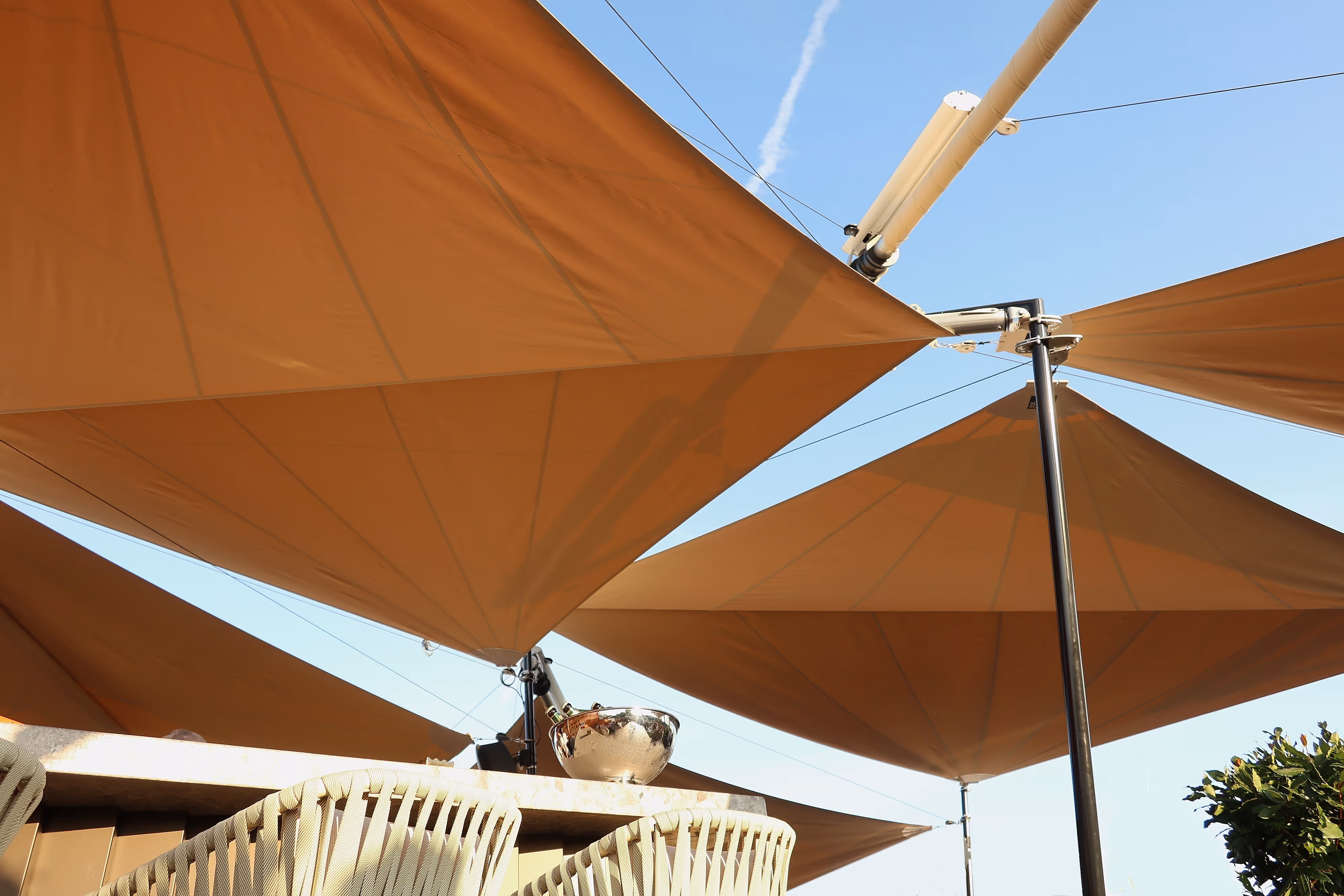 Man sieht die Bar des Hotels Storchen in Zürich und die errichteten Sonnensegel von Hermann Guggenberger.Sieben freistehende SunSquare-Segel auf der Rooftop-Bar „The Nest“ in Zürich – vollautomatischer Sonnen- und Regenschutz aus feuerresistentem Gewebe.