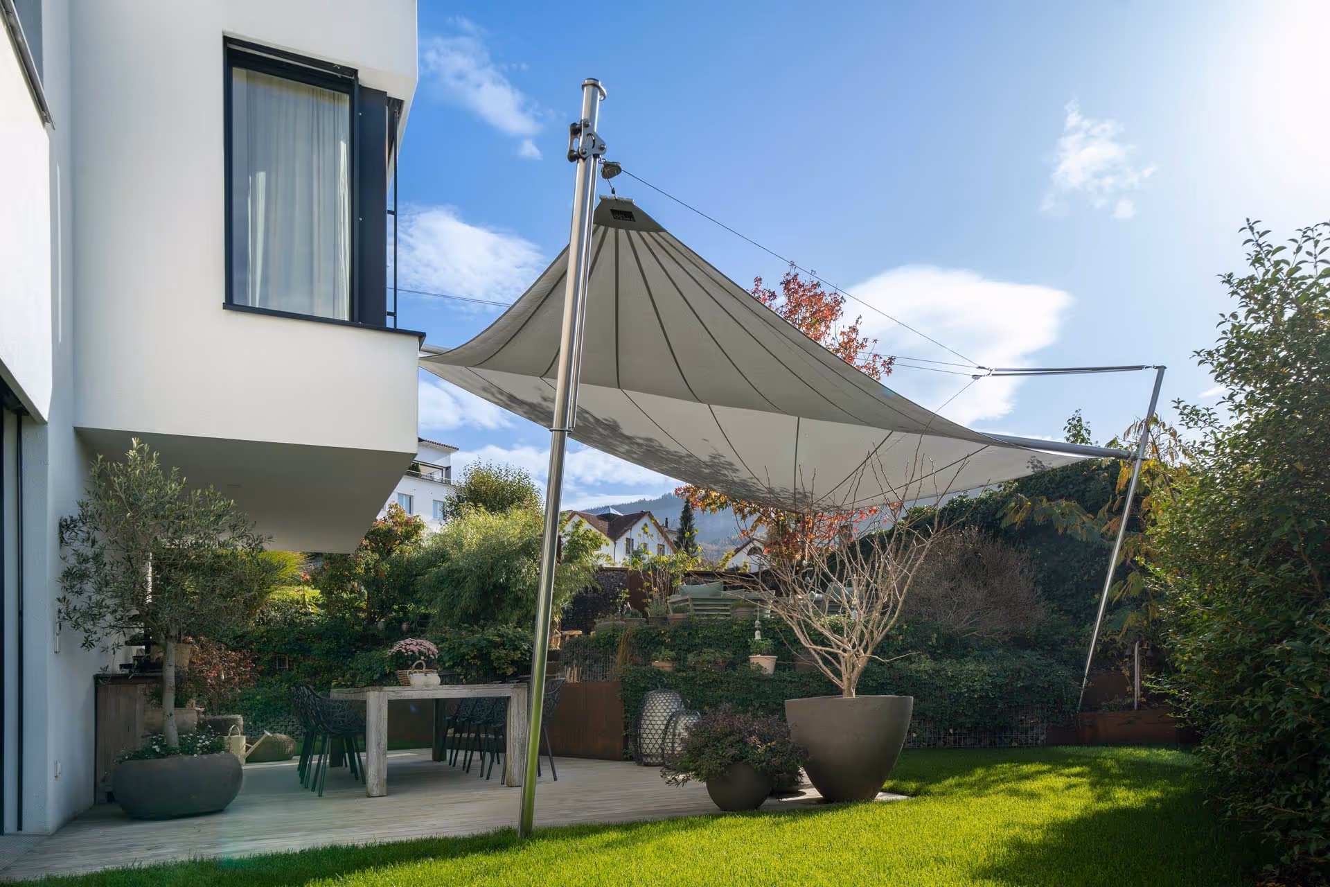 Side view of the complex, you can see a large wooden terrace that you enter from the house and one level higher is another terrace area, which is also protected by the SunSquare sail.