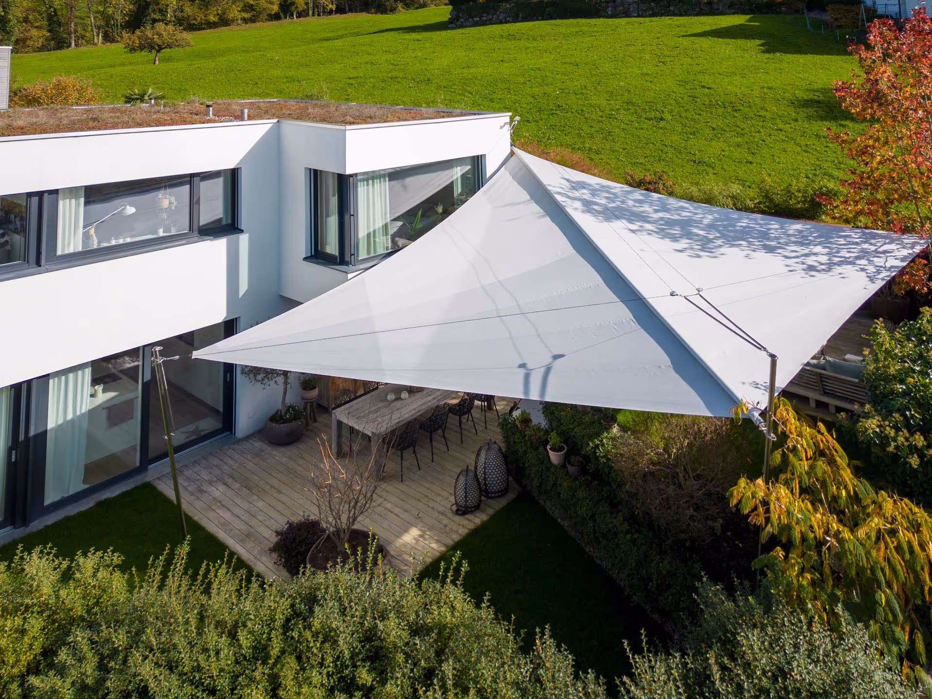 Beschattete Lounge-Zone unter dem Strahlensegel – gemütlicher Outdoor-Bereich mit maximalem Komfort.