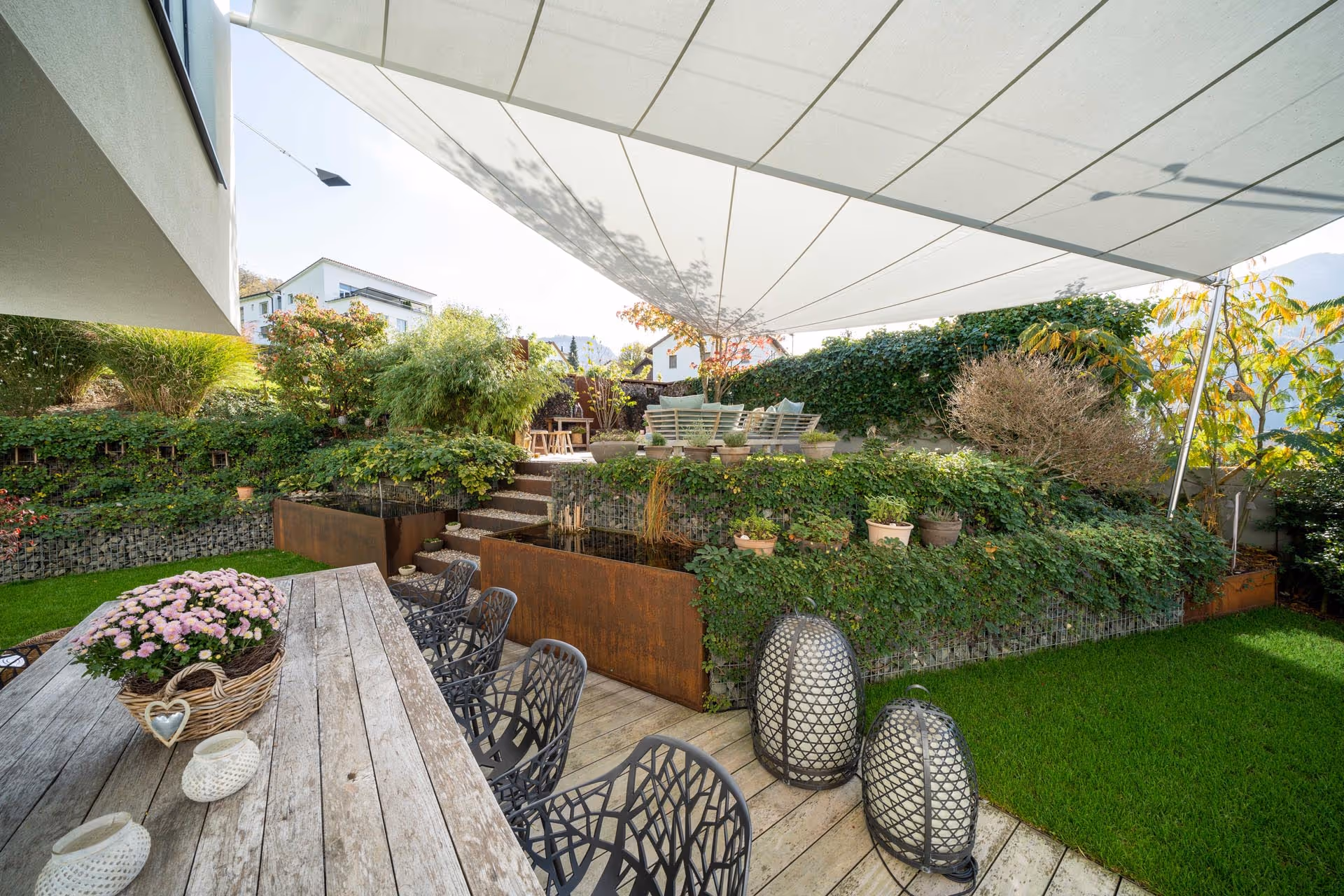 SunSquare Federzug-Anlage mit 55 m² Orchestra Strahlensegel – eleganter Sonnen- und Regenschutz für zwei Terrassen-Niveaus.