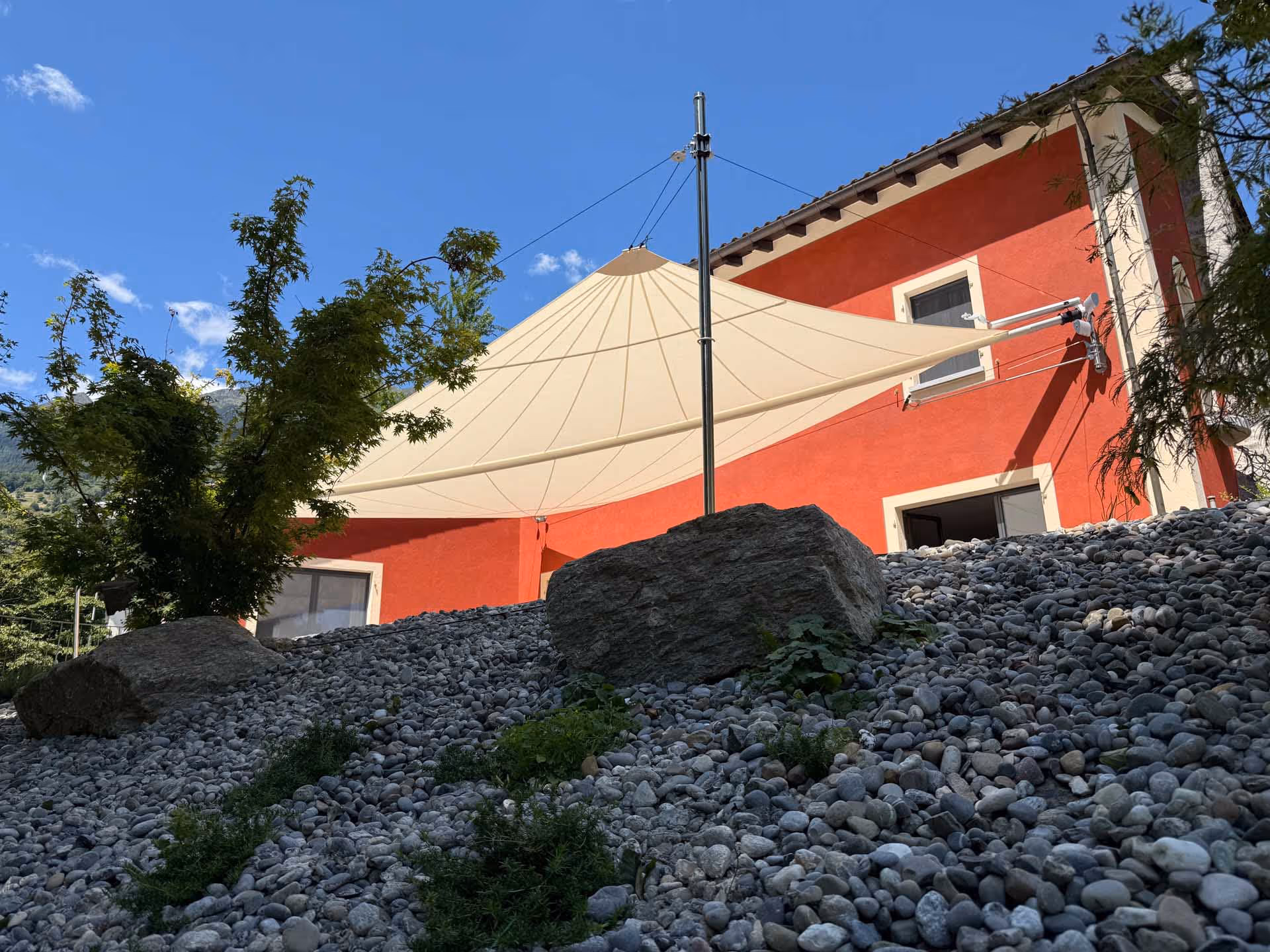 Architektonisch klare Linienführung des Strahlensegels – hochwertige textile Architektur für privaten Outdoor-Komfort.