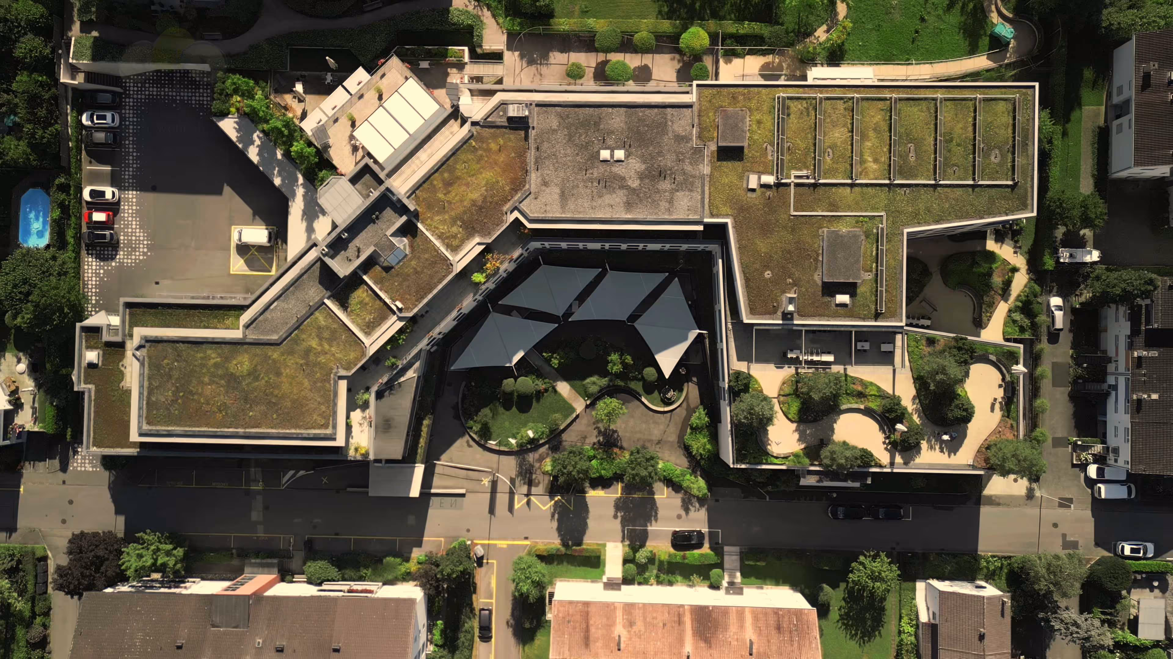 Eine Luftaufnahme des Wohnheims Dreilinden in der Schweiz zweigt die installierten SunSquare Segel.