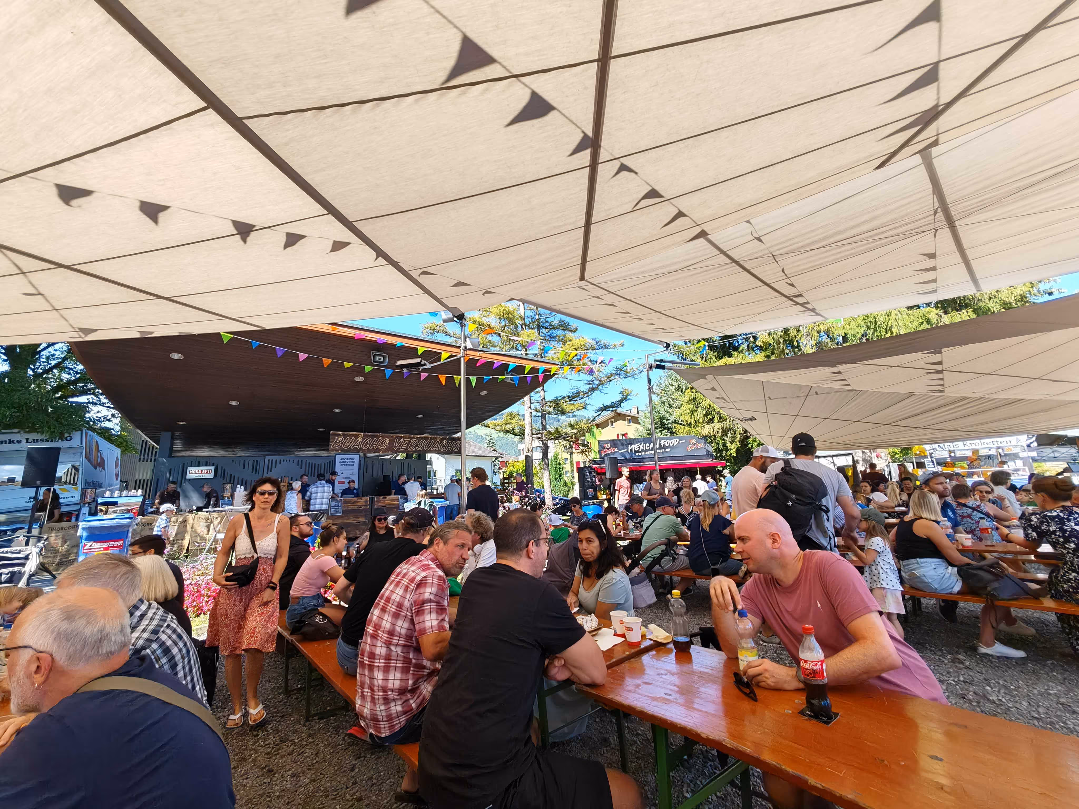 Im Schatten unter einem Sonnensegel sitzt man besser - das zeigt dieses Bild von einem Volksfest in der Gemeinde Buochs.