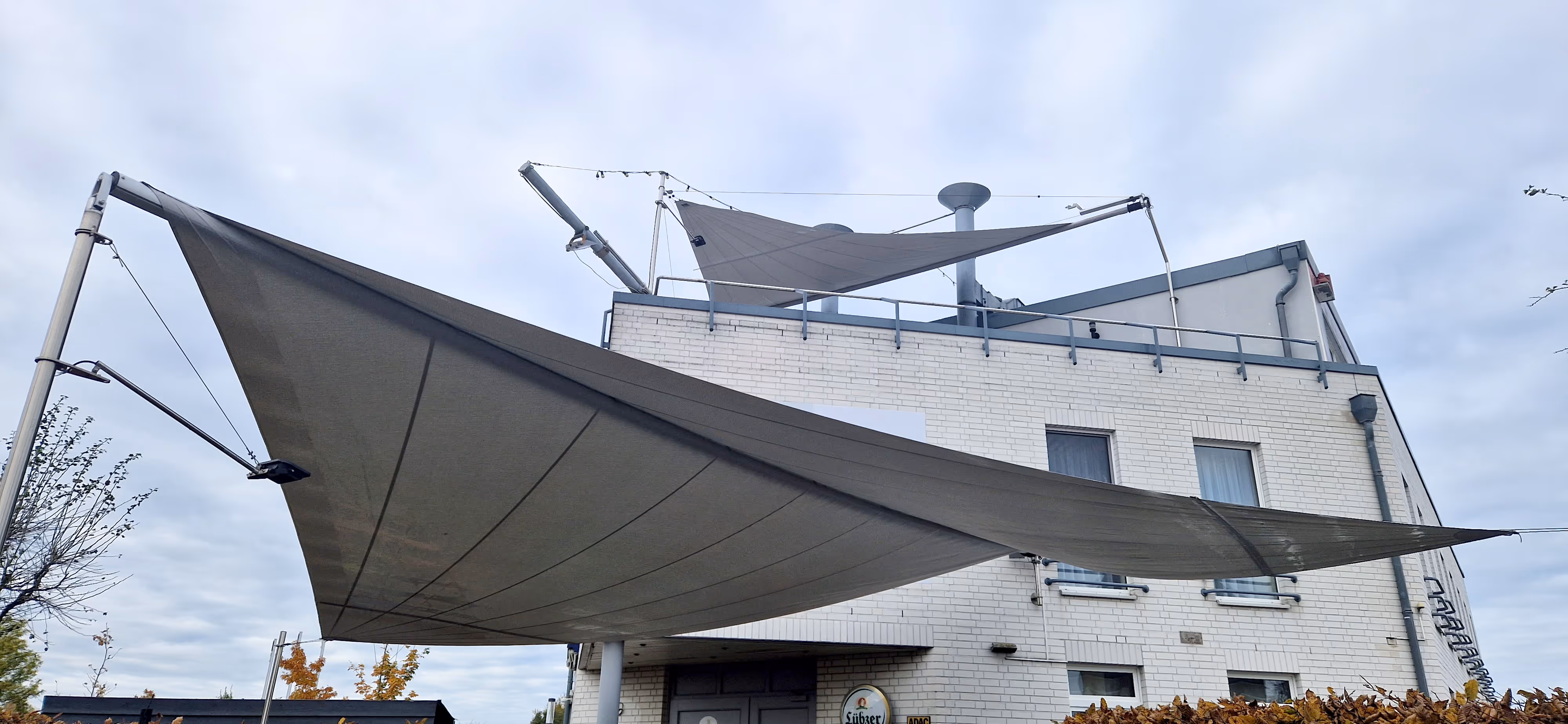 Eine Aufnahme aus dem Garten, der von unten beide SunSquare Anlagen zeigt. Auch jene Anlage auf der Dachterrasse ist zu sehen.