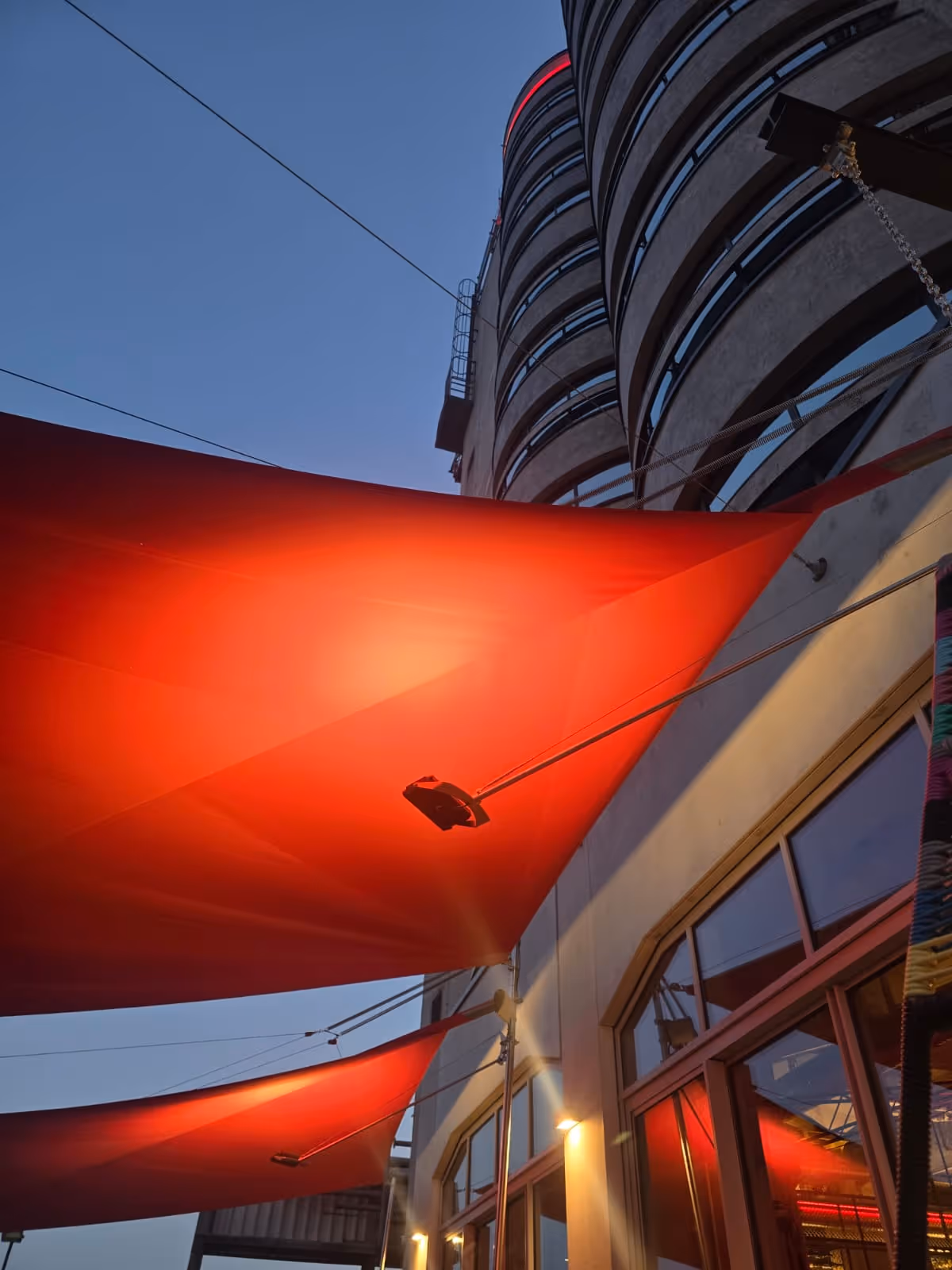 Abendstimmung mit eingeschalteter SQLED-Beleuchtung unter dem SunSquare-Segel – stimmungsvolles Licht.