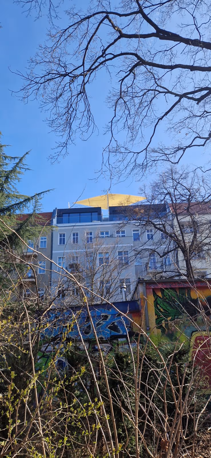 Von weit weg aufgenommen. Sonnensegel statt Pergola.