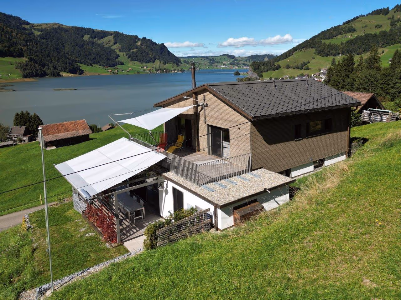 Eine Ansicht von der Seite zeigt das hübsche Wohnhaus mit den beiden SunSquare Sonnensegel-Anlagen.