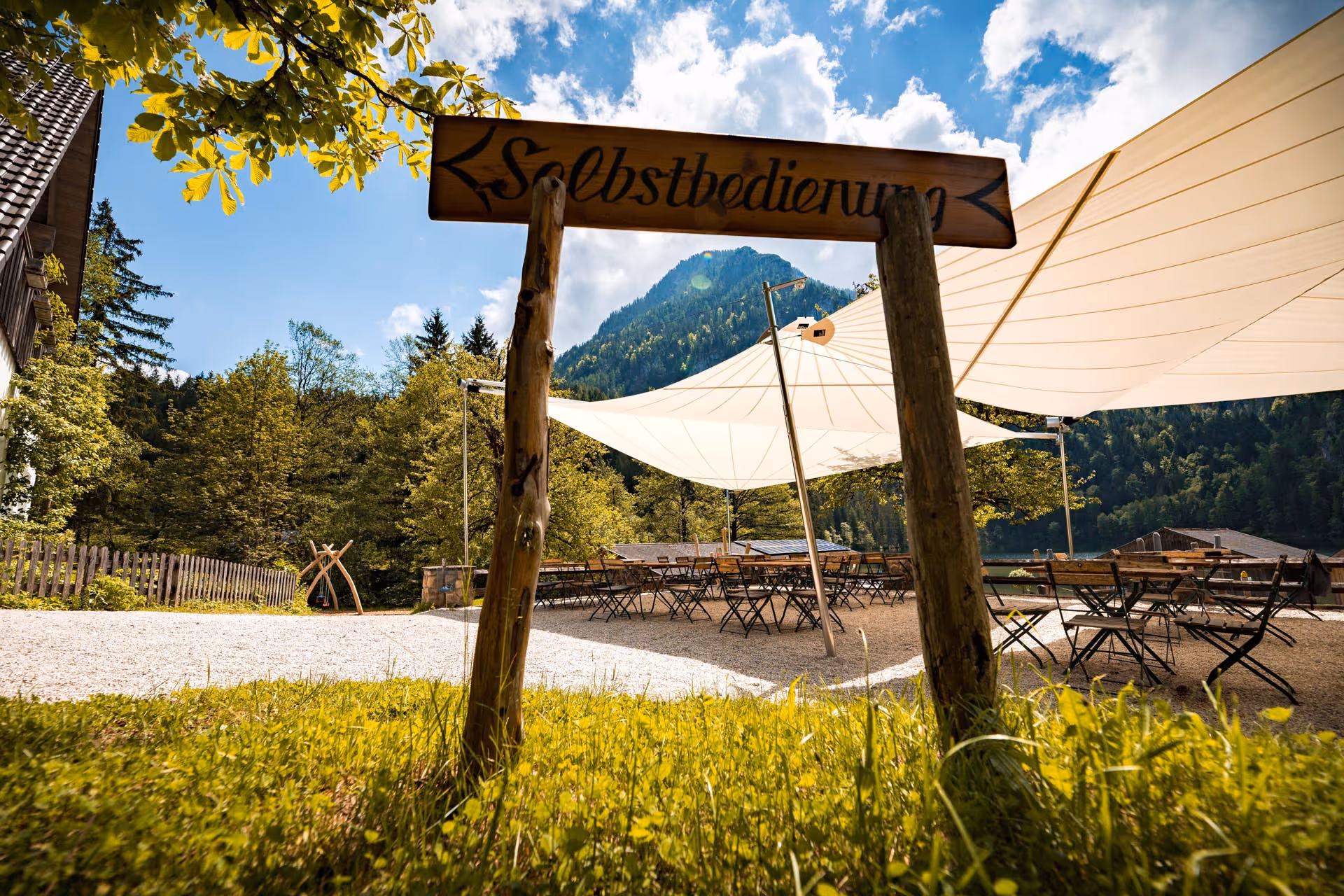 Ein Schild macht auf Selbstbedienung aufmerksam im Hintergrund sieht man die SunSquare Segel.