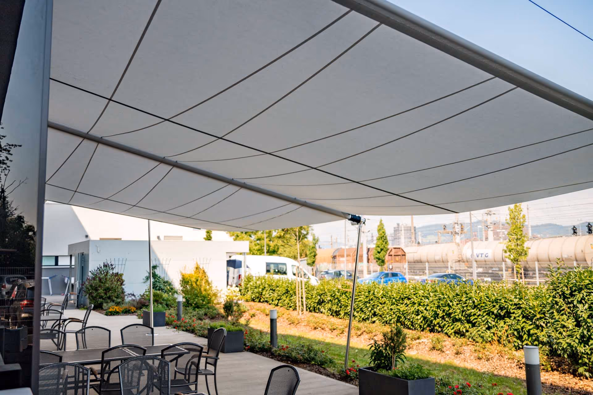Beschatteter Sitzbereich unter der Rechtecksegel-Anlage – komfortabler Outdoor-Raum bei jedem Wetter.