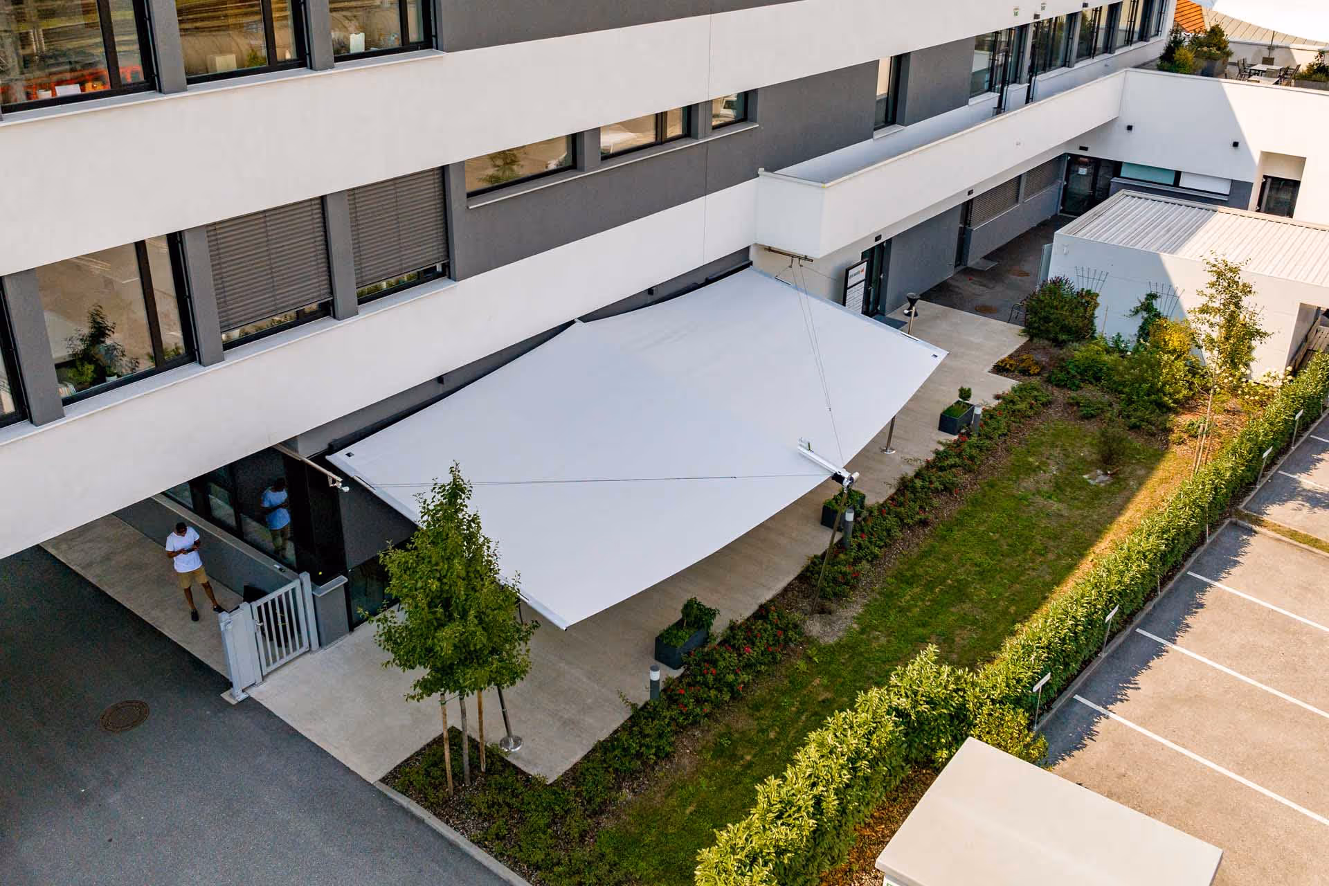 Sitzgruppe unter der Rechtecksegel-Anlage – geschützter Bereich für Begegnung und Kommunikation.