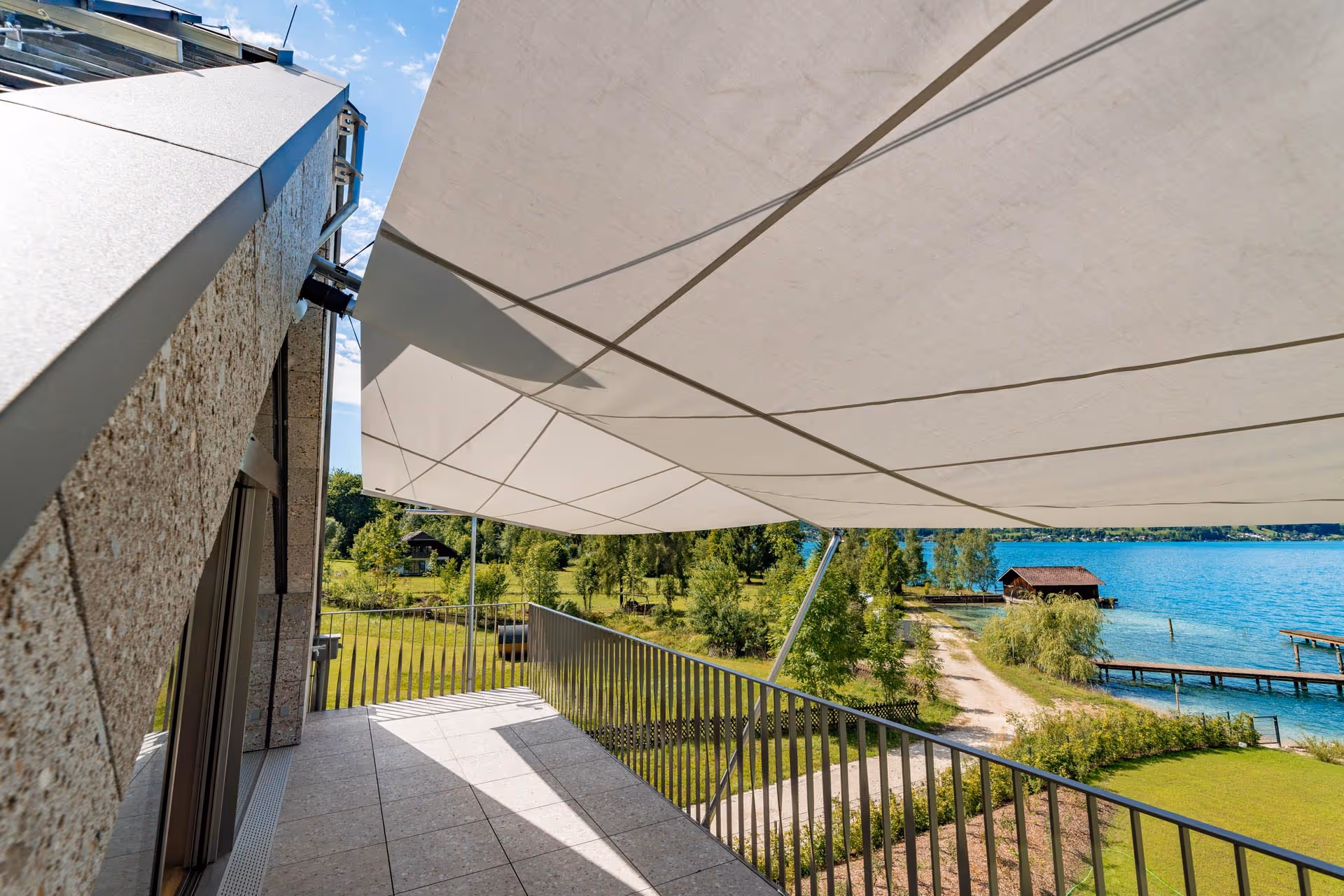 Ein Blick von unten auf das Sonnensegel im Hintergrund der See.