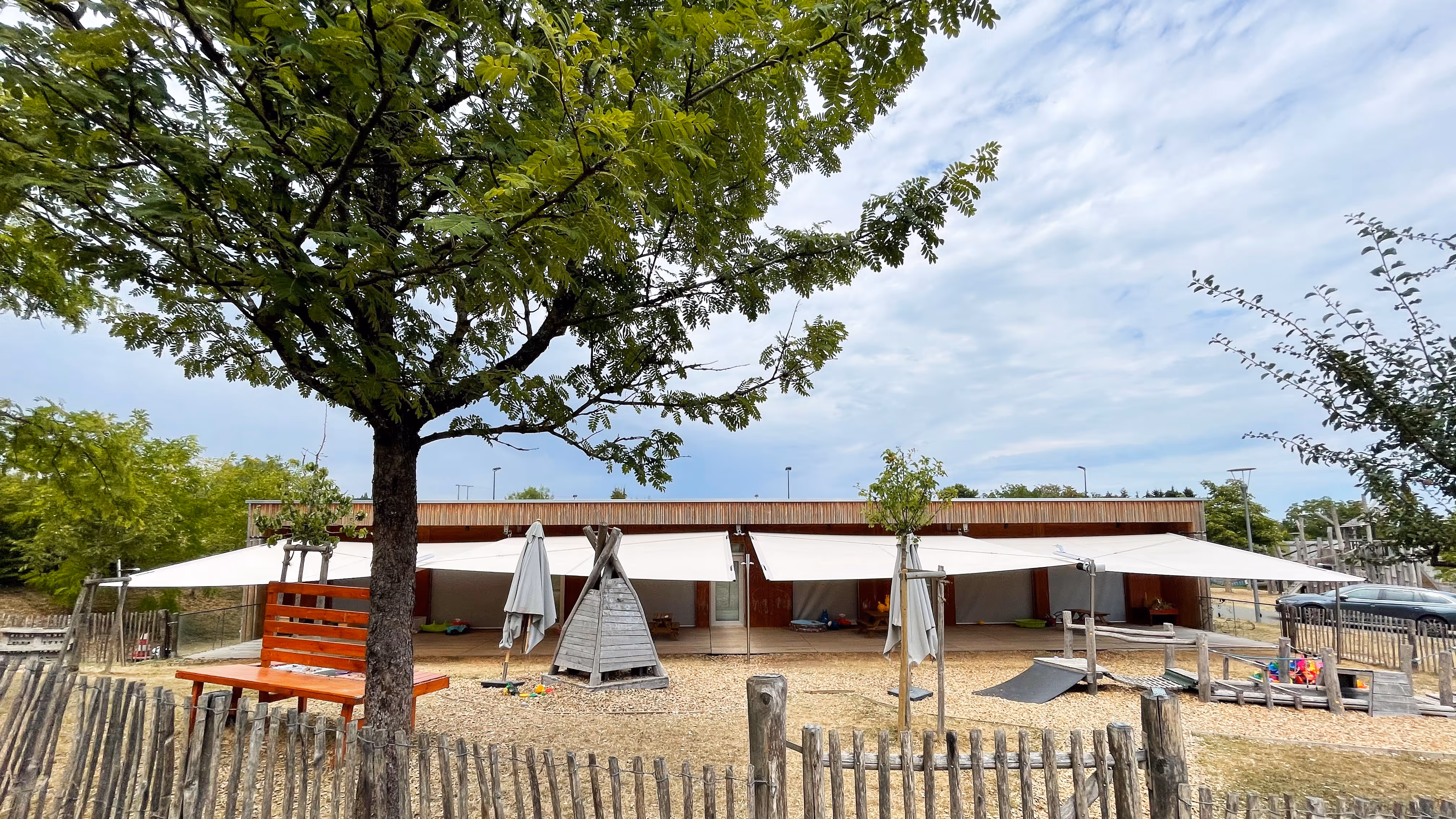 Ein Blick von der Ferne auf den Kindergarten und die große Schattenfläche durch die SunSquare Sonnensegel.